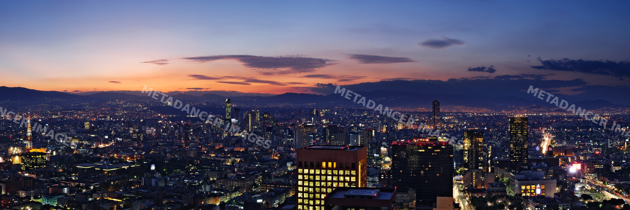 Mexico city skyline with city lights and mountain backdrop