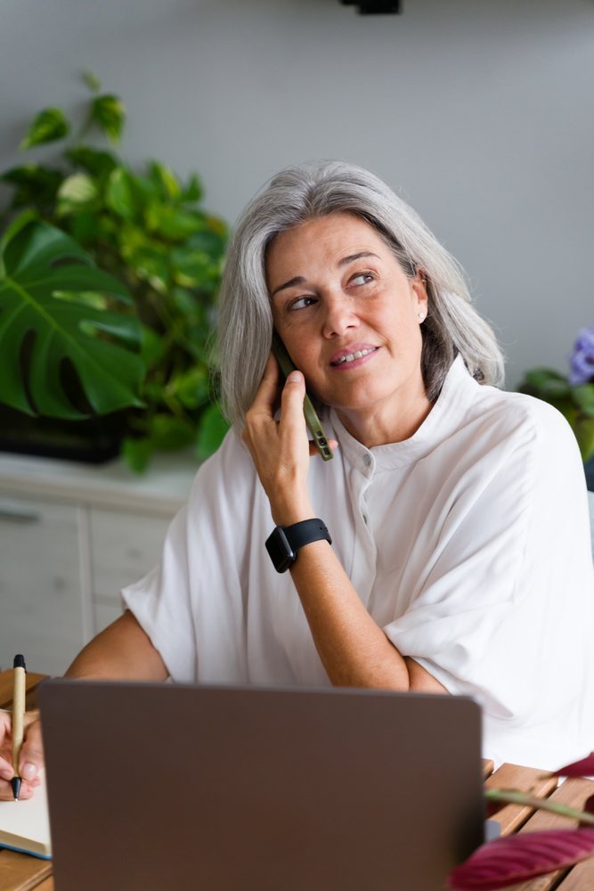 Mature white woman working and talking on phone
