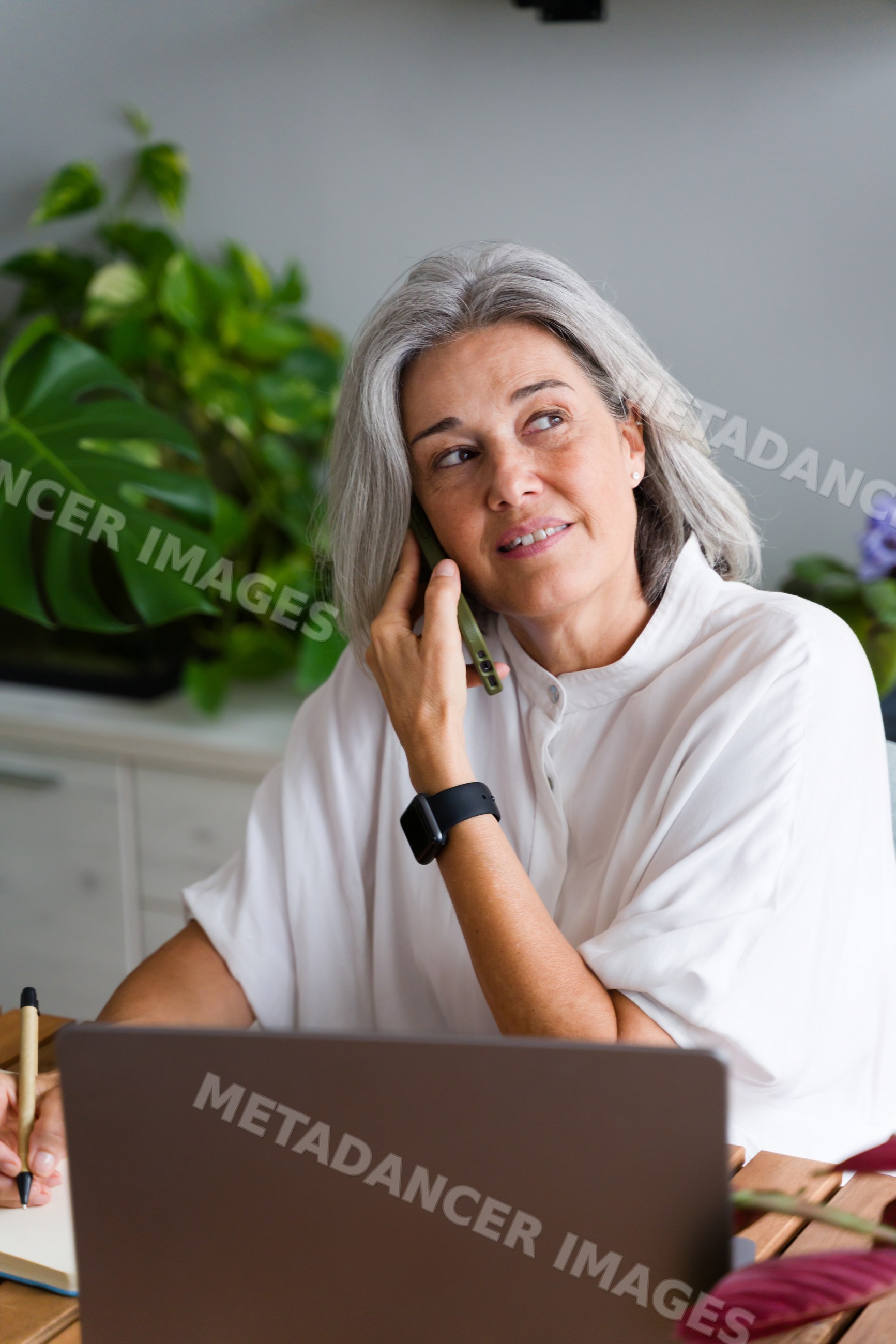Mature white woman working and talking on phone