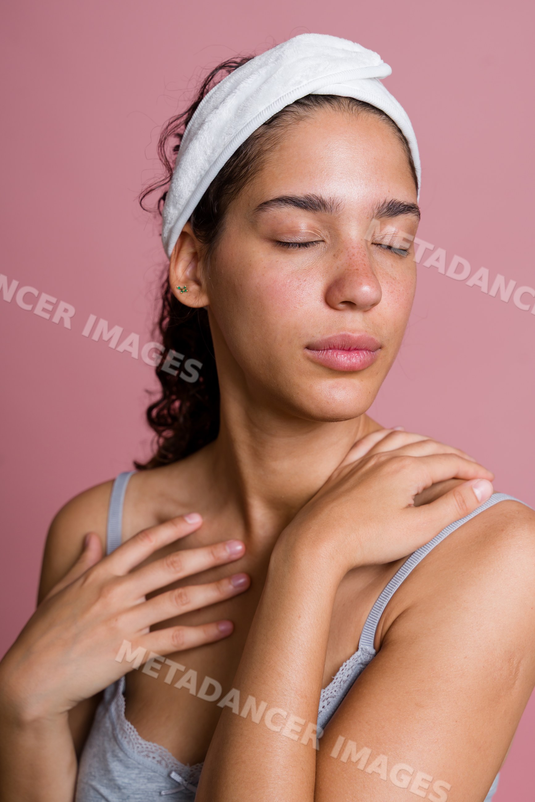 Hispanic woman with closed eyes and white headband