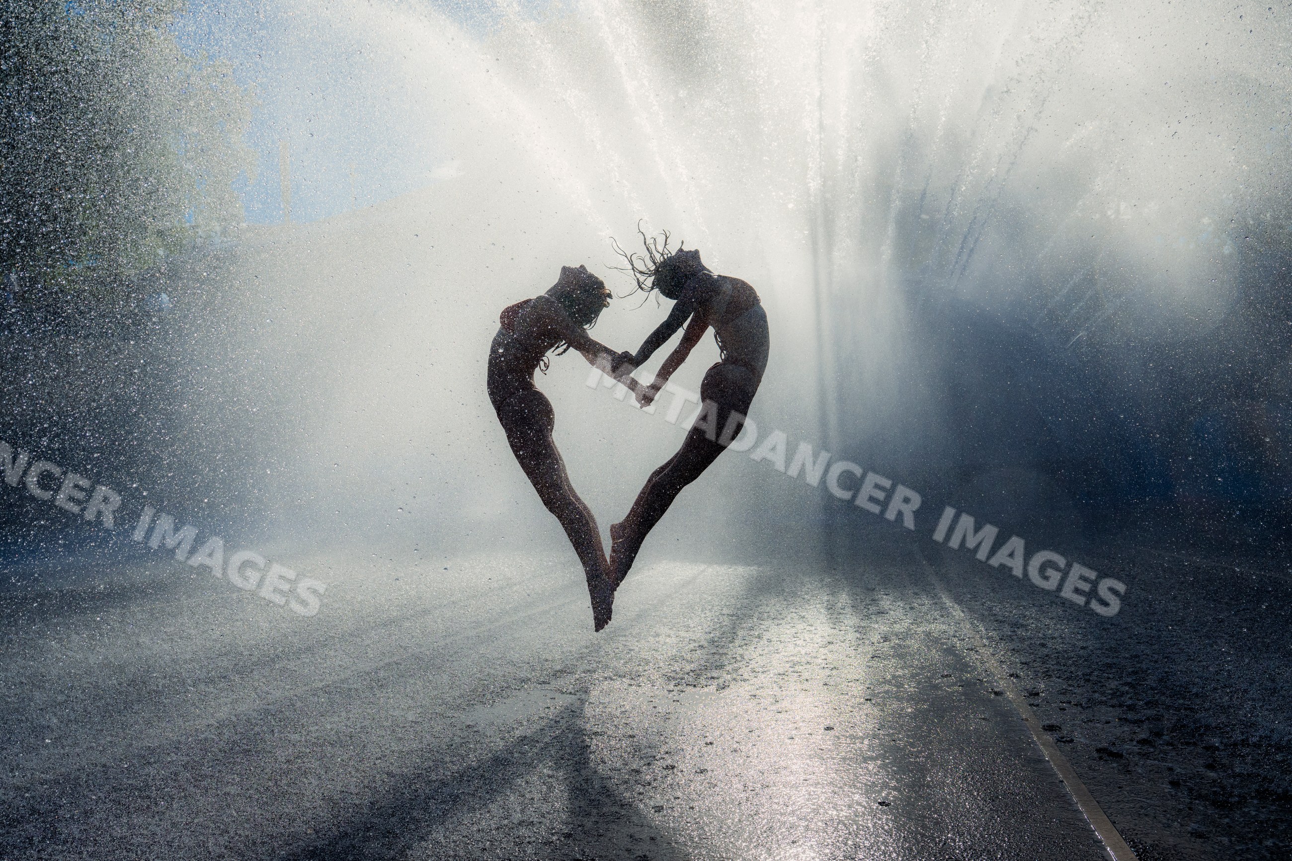 Two white women jumping and forming heart shape