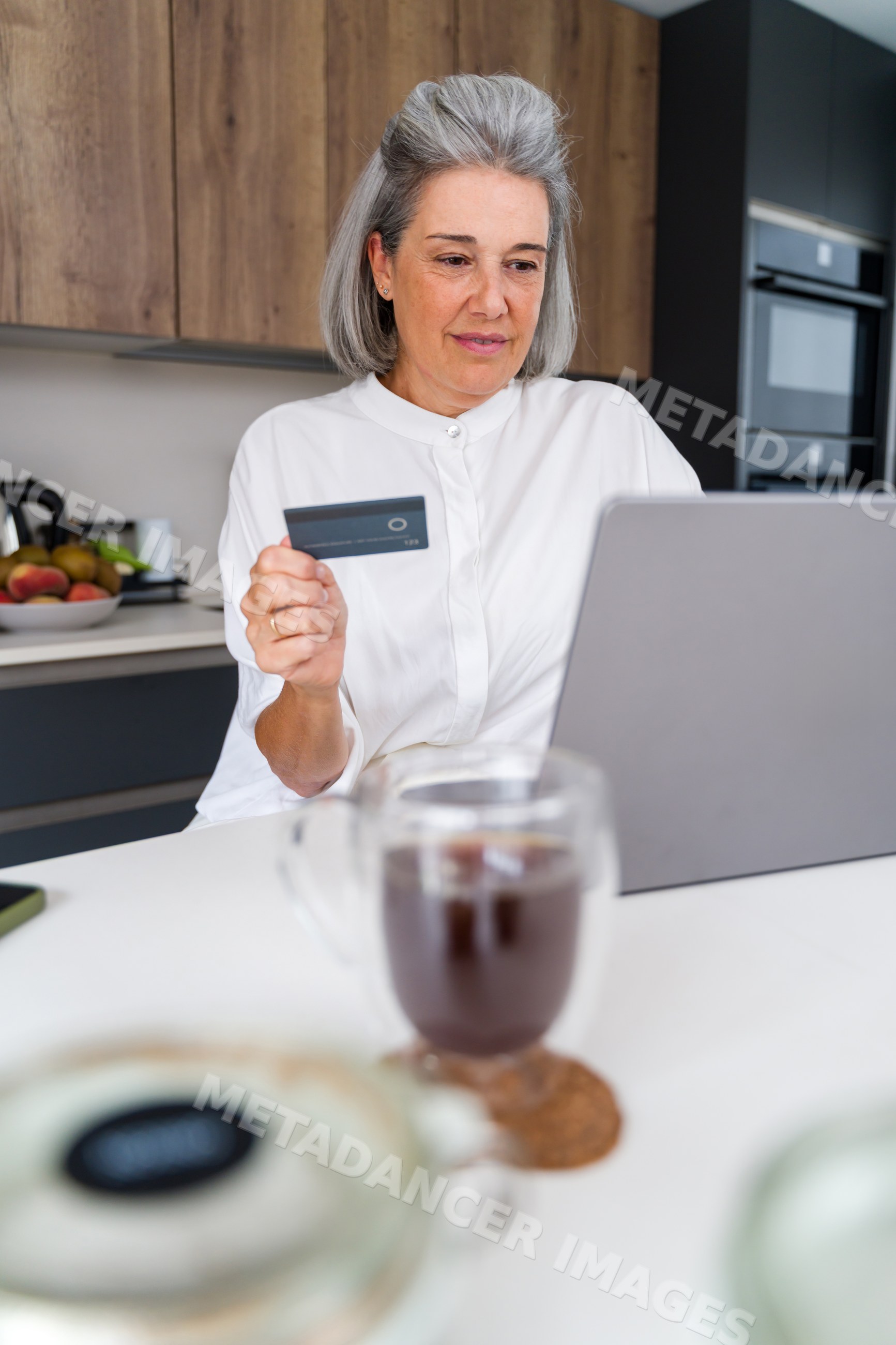 Senior white woman using laptop and credit card for online shopping