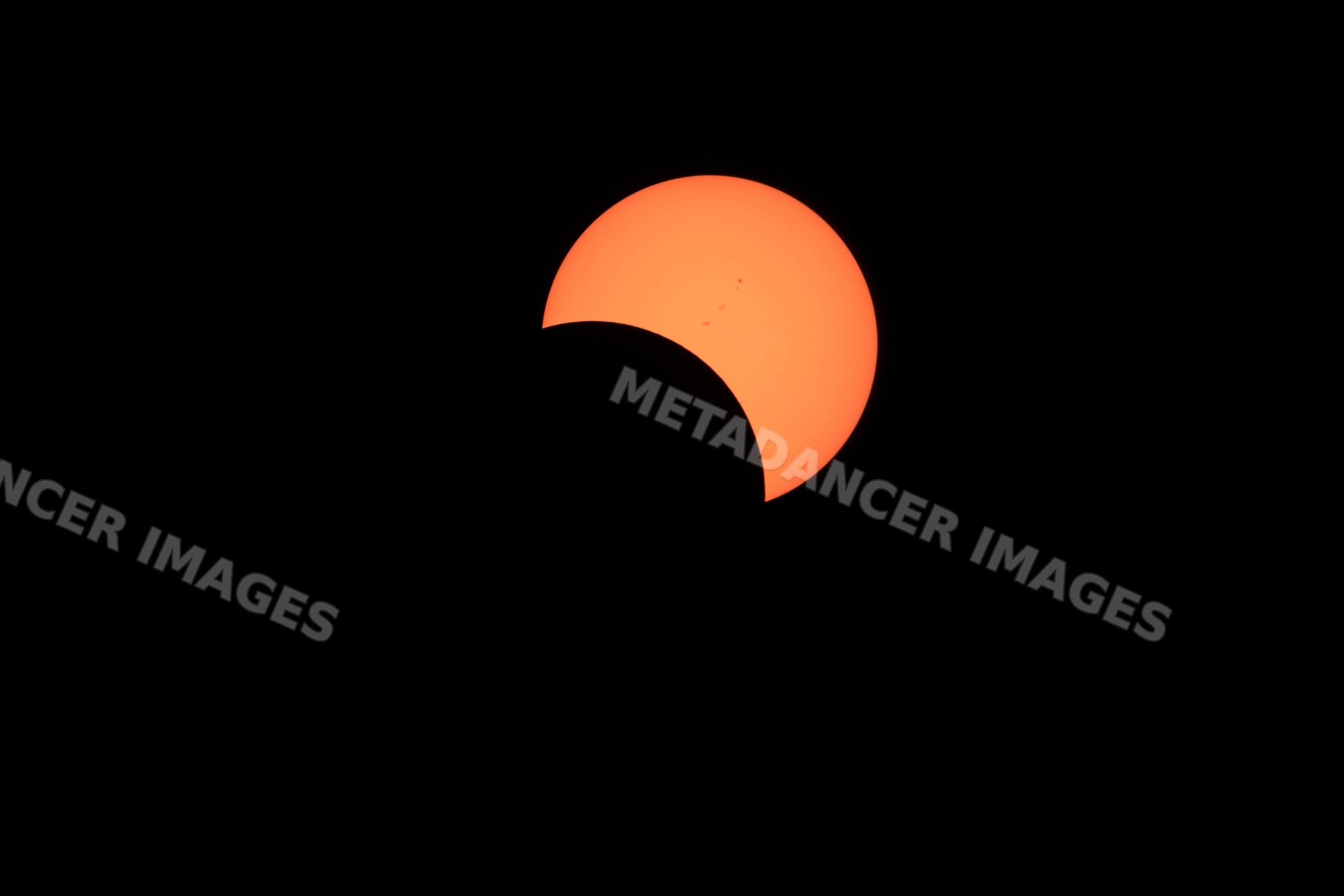Solar eclipse with moon partially covering sun over Los Angeles