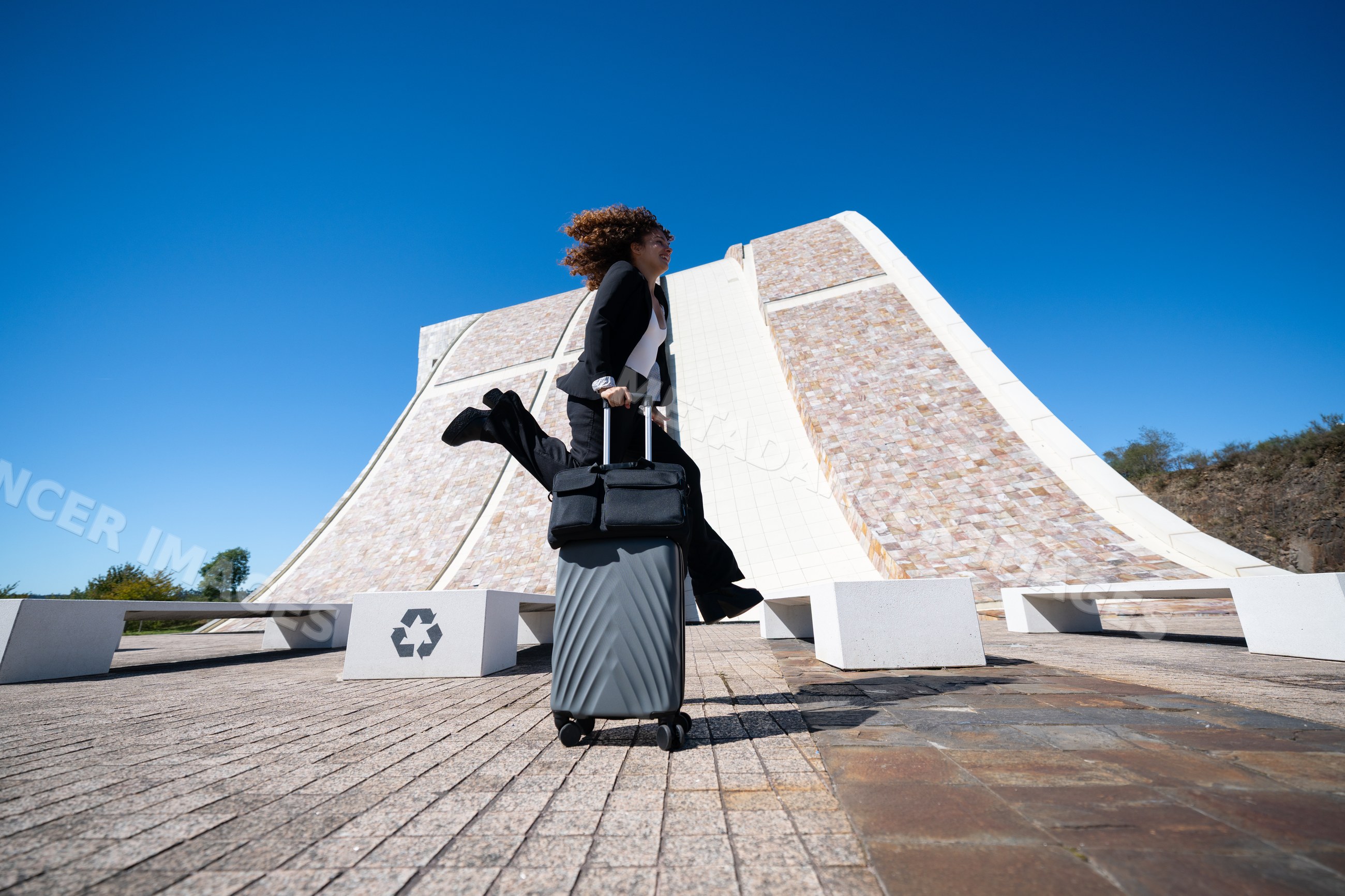 Businesswoman jumping with suitcase