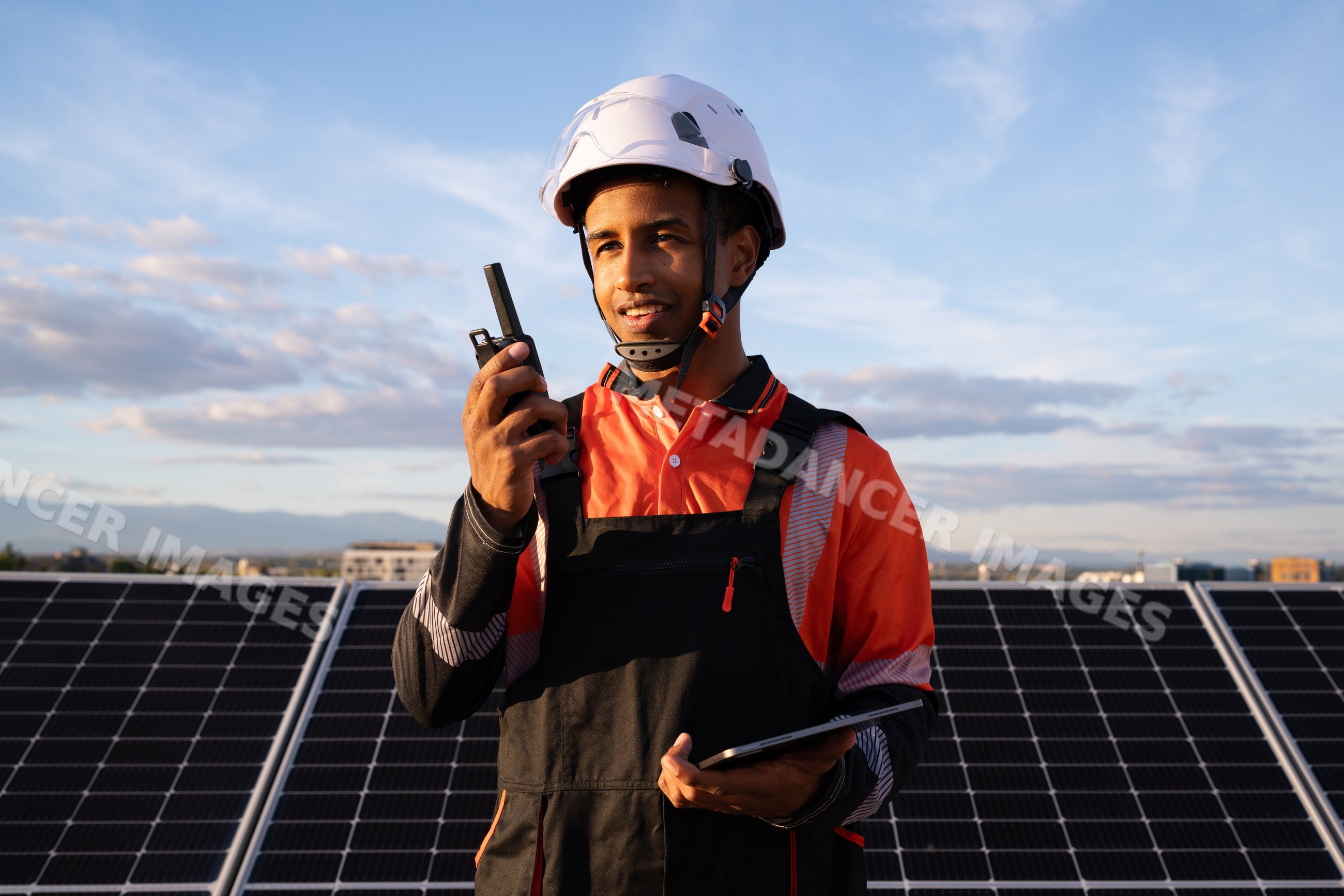 Technician inspecting solar panels communicating with walkie talkie