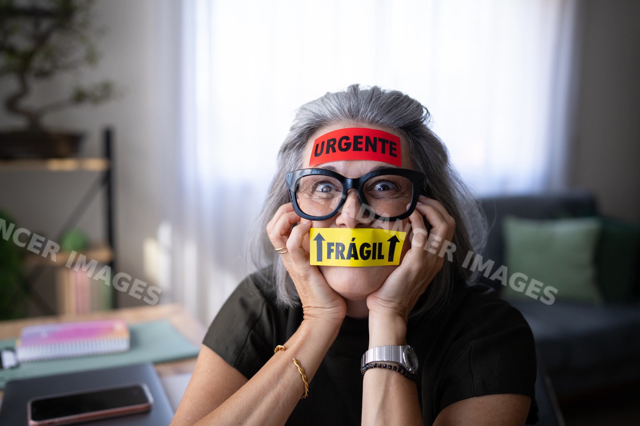 Older white woman wearing urgent and fragile stickers on her face