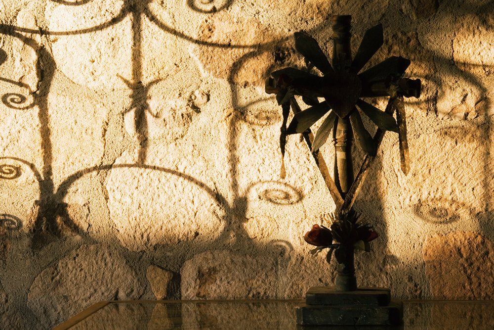 Cross casting shadows on textured wall