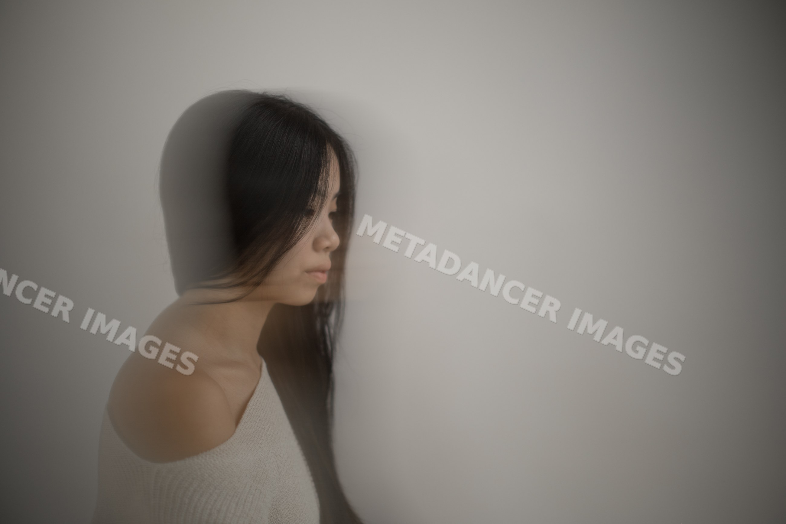 Emotional portrait of Southeast Asian woman with long hair against
