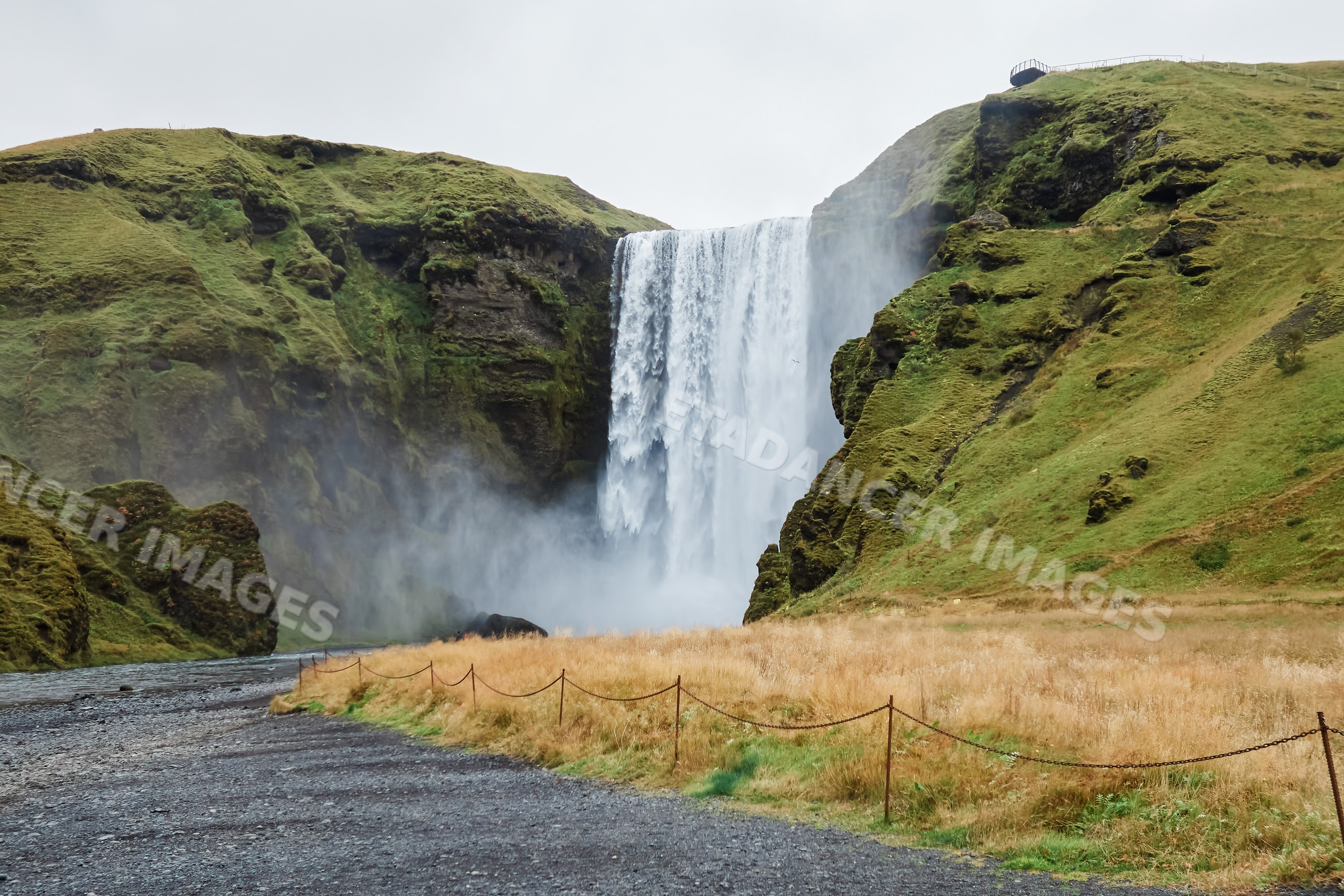Waterfall flowing down cliffs with grassy hills