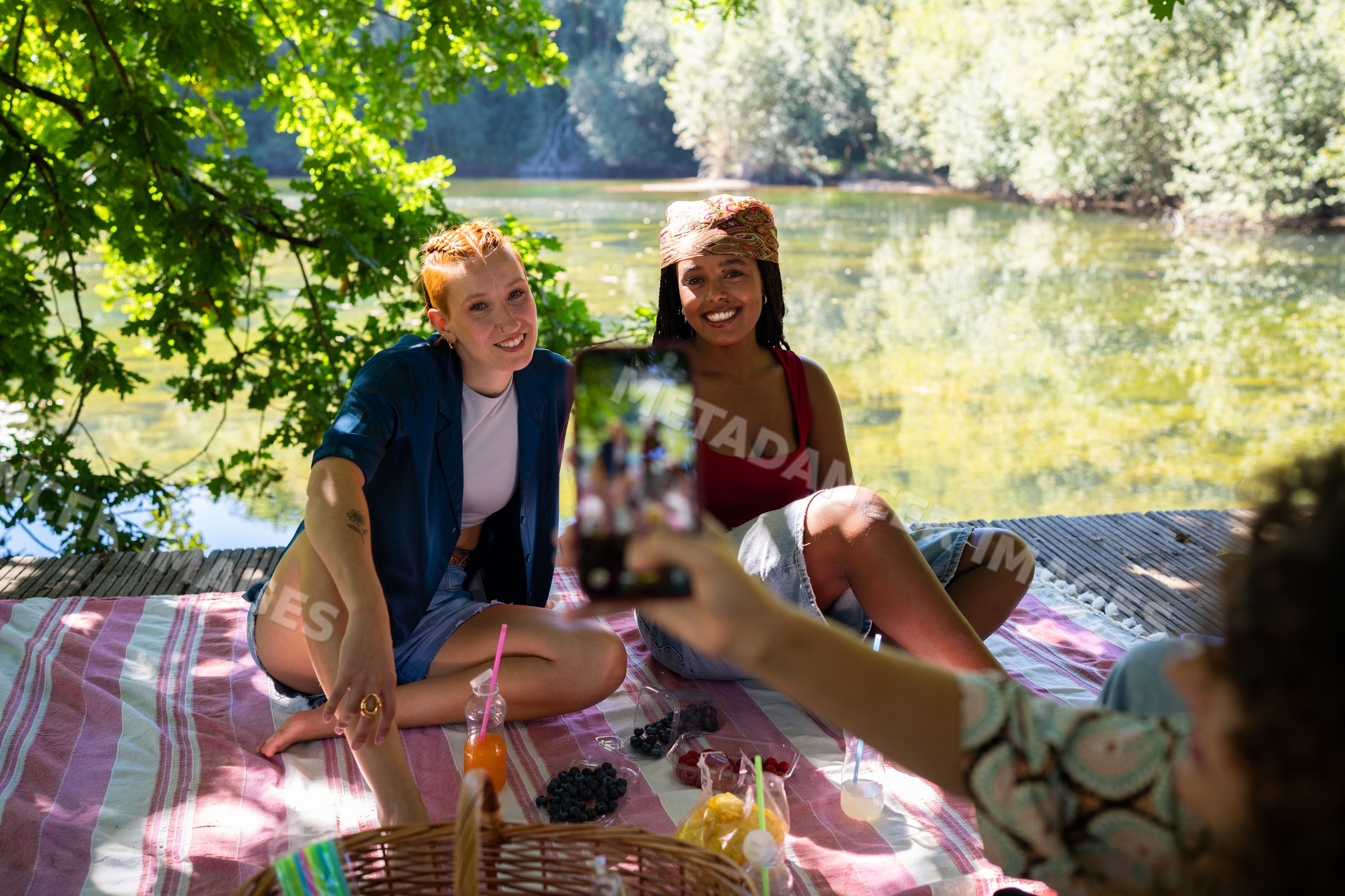 White and African American women enjoying a picnic by the lake
