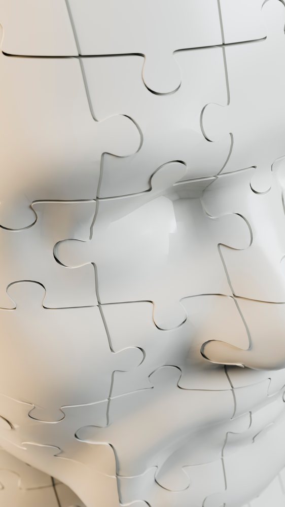Human face made of interconnected white puzzle pieces