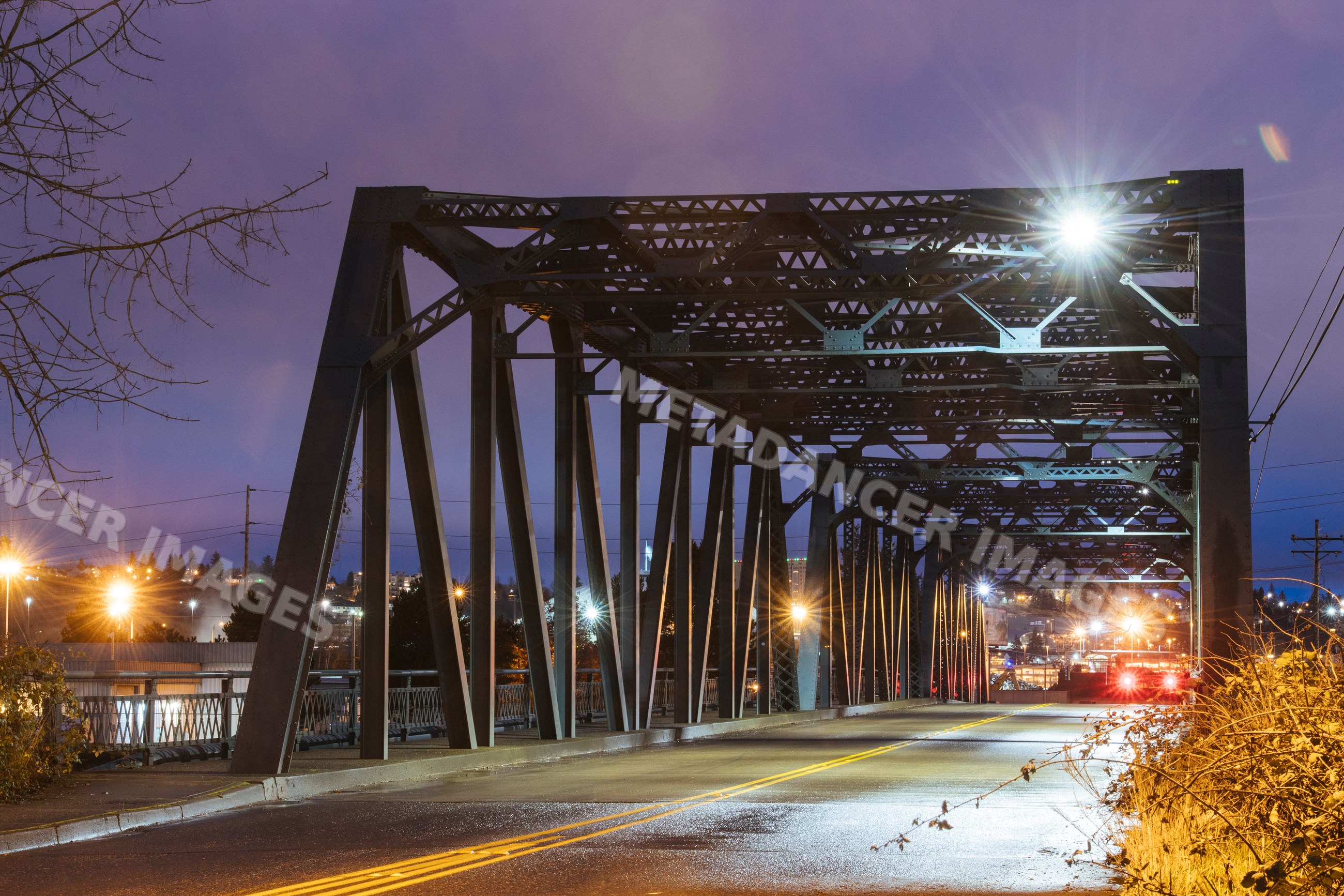 Steel bridge with roadway and street lights in Tacoma at night