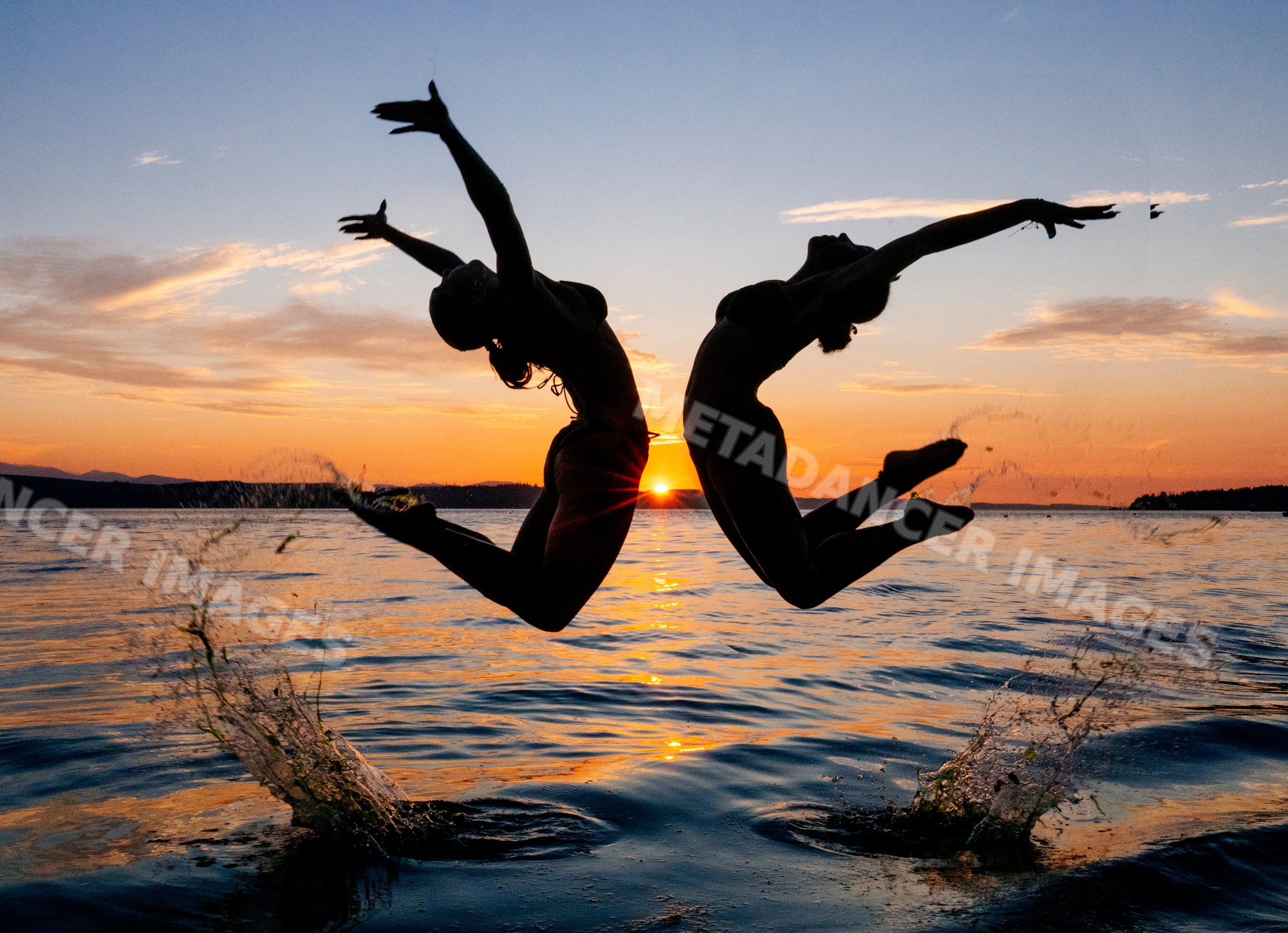 Two women practice partner yoga acrobatics leaping from water