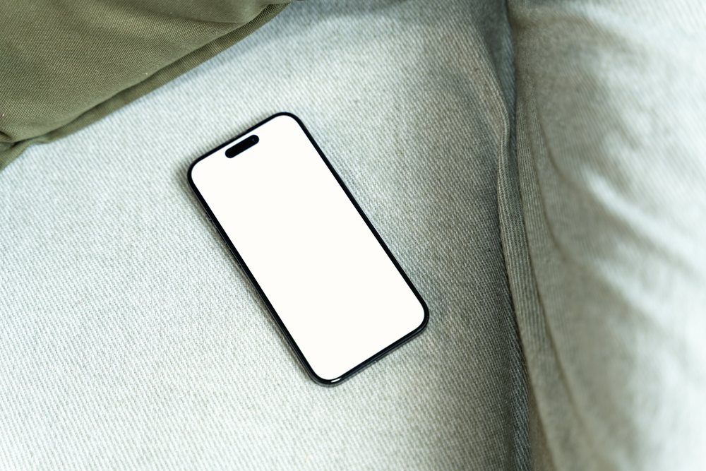 Smartphone with blank screen on fabric surface