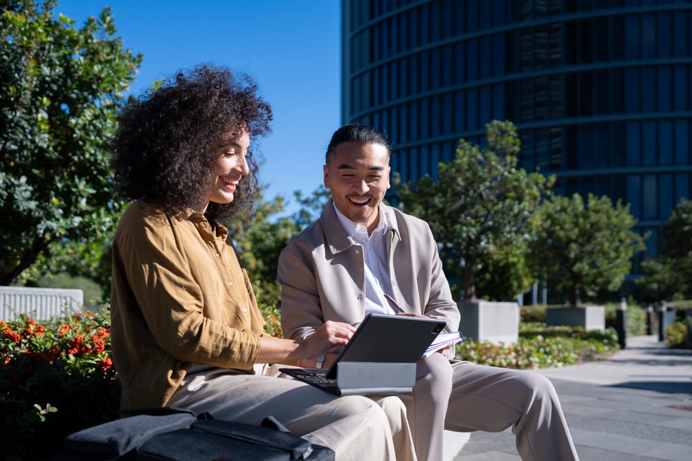 Two people collaborating with a tablet outdoors