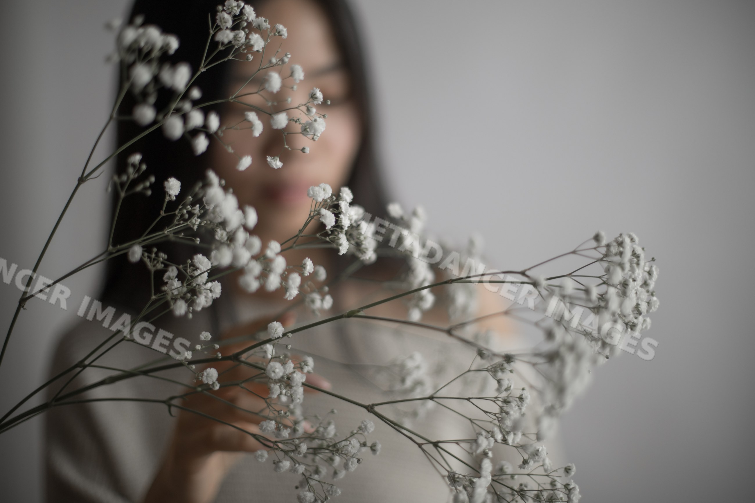 Portrait of Southeast Asian woman holding delicate white baby's breath