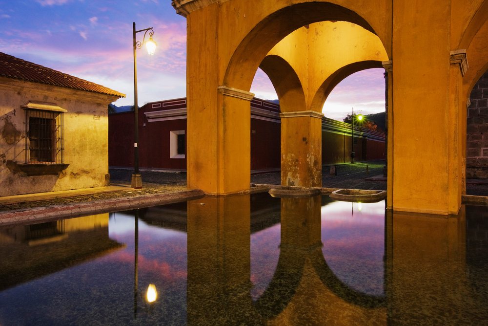 Tanque de la union reflecting colonial arches at twilight guatemala