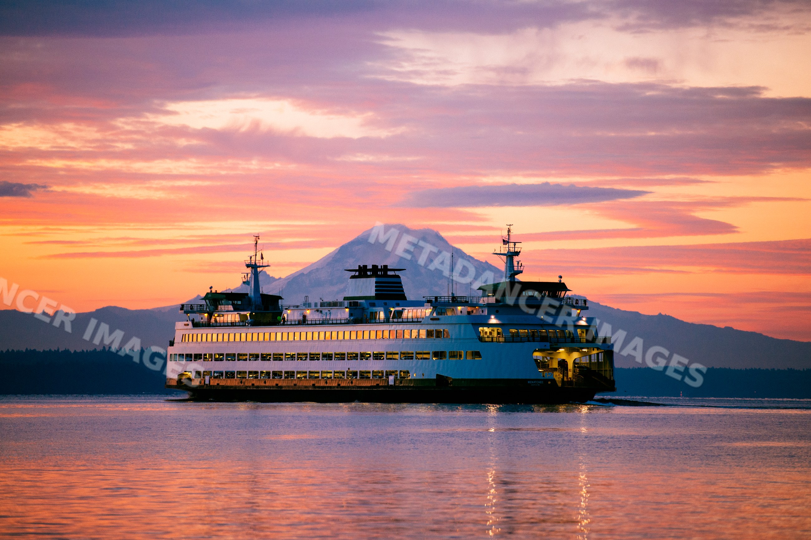 Ferry sailing near Bainbridge Island with mount rainier at sunset