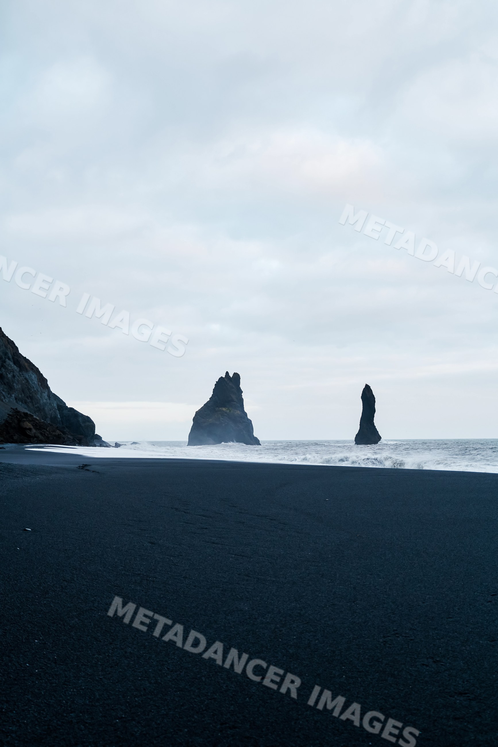 Black sand beach with ocean rock formations