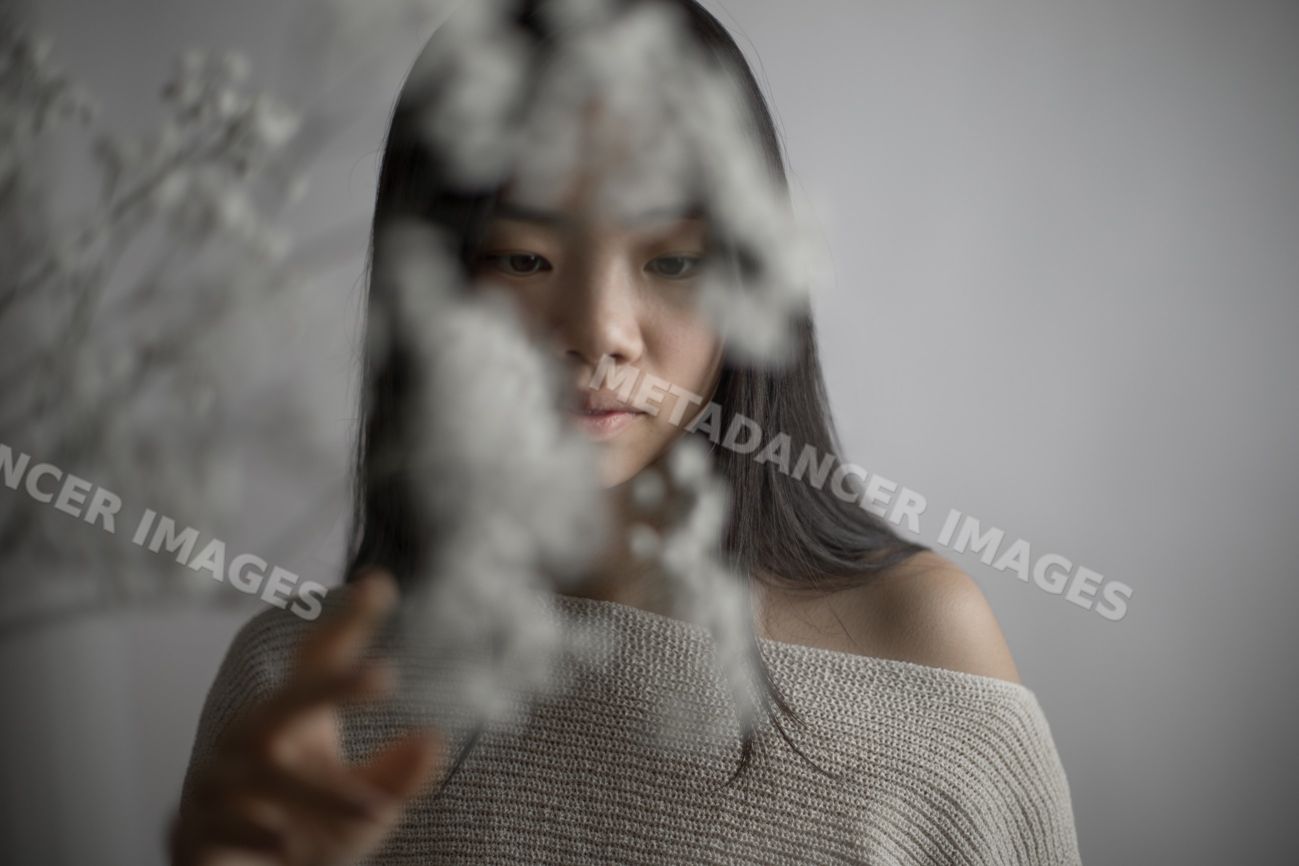 Young Southeast Asian woman holding delicate dried flowers