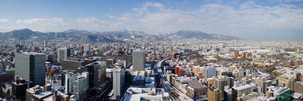 City skyline with snowy buildings and mountains, hokkaido, japan