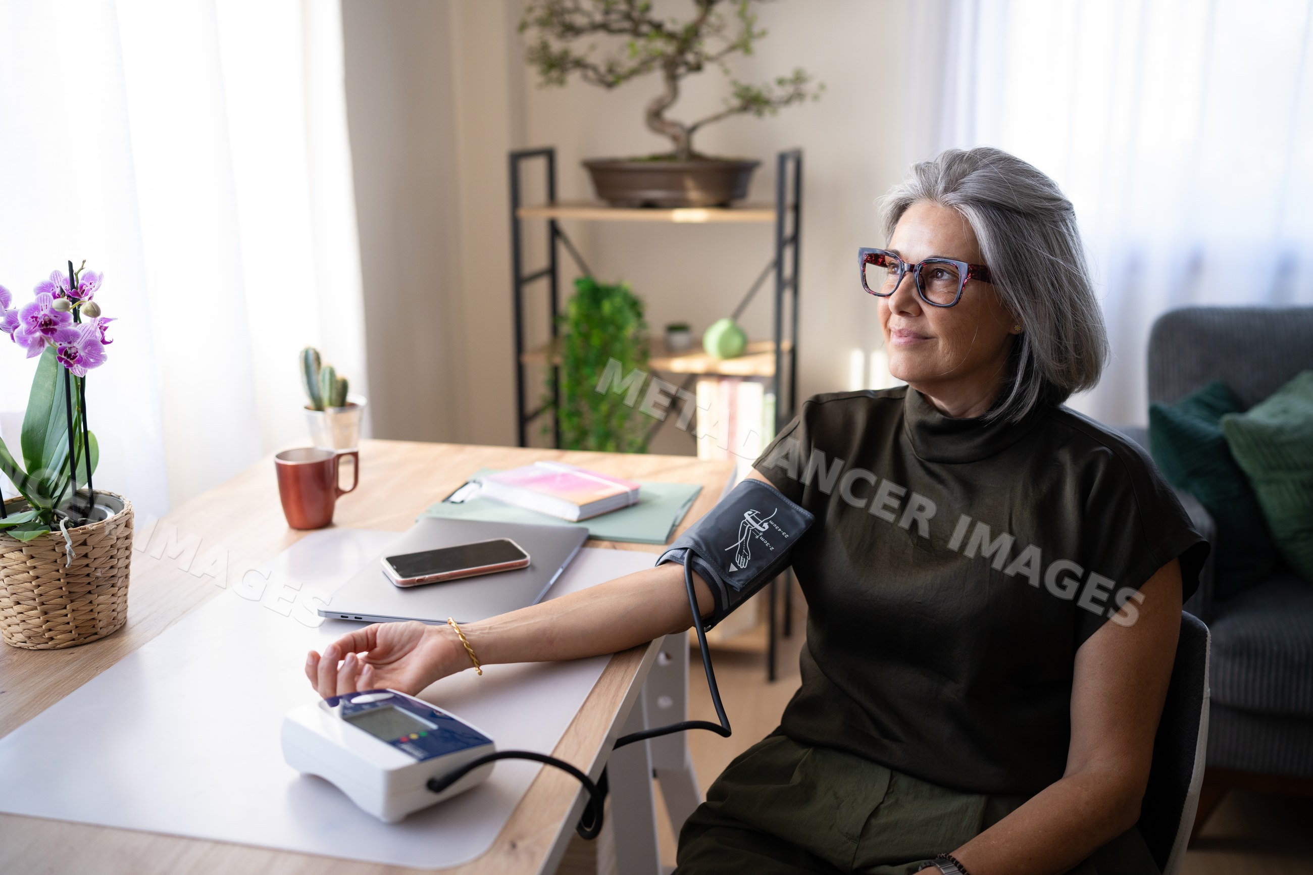 White woman measuring blood pressure with digital monitor