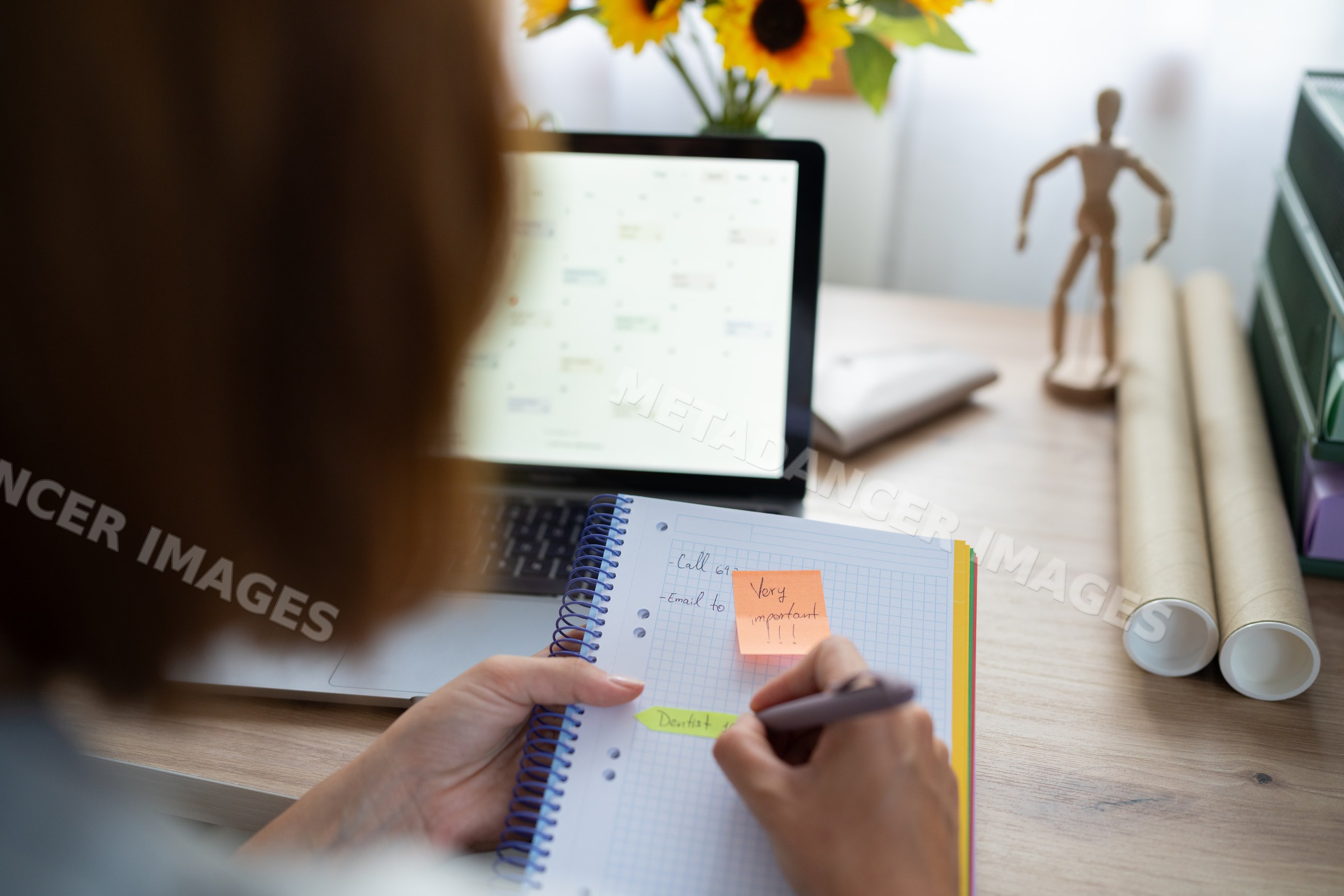 A white woman writes important notes in her notebook