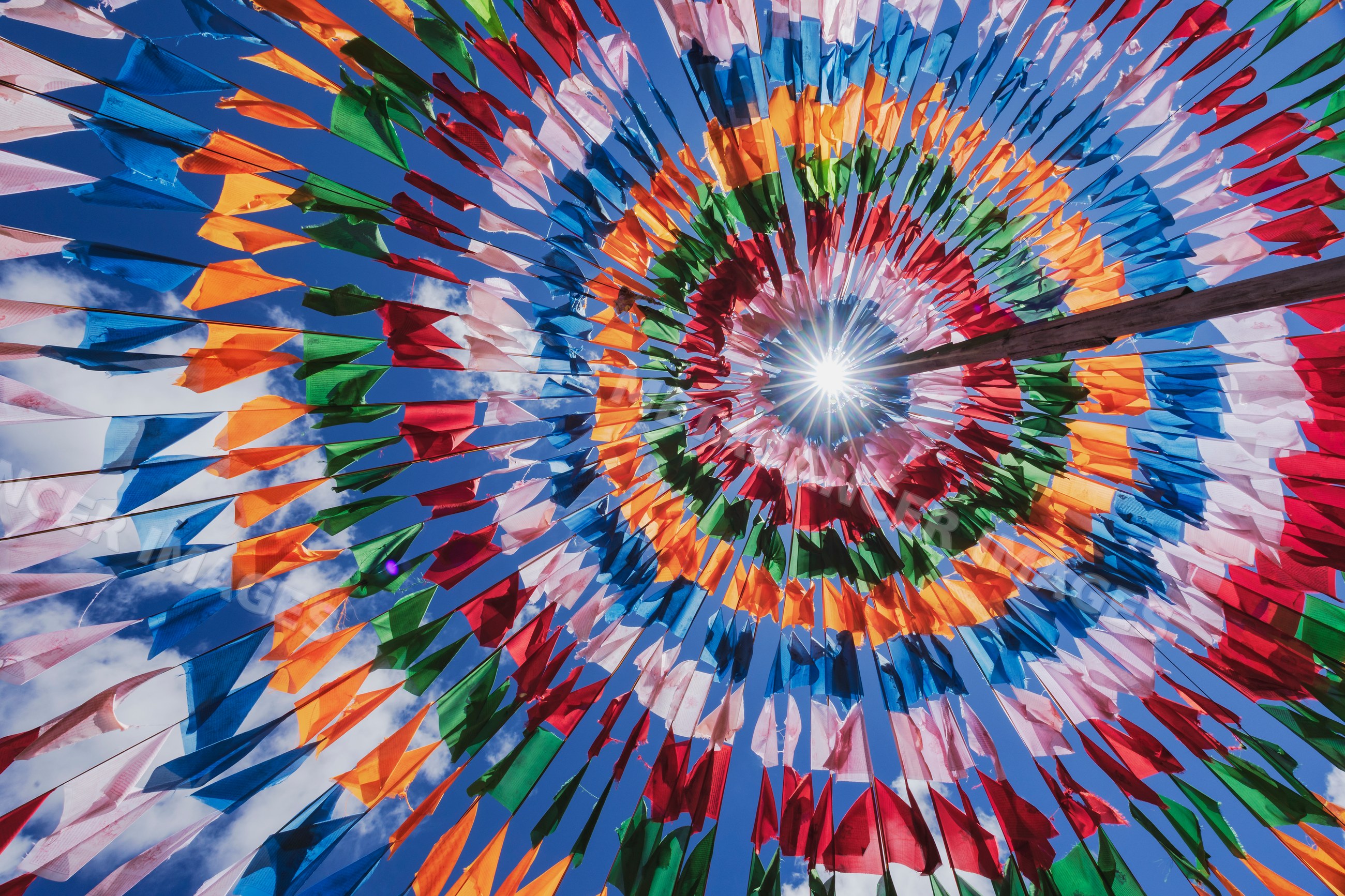 Colorful prayer flags arranged inside a tent structure
