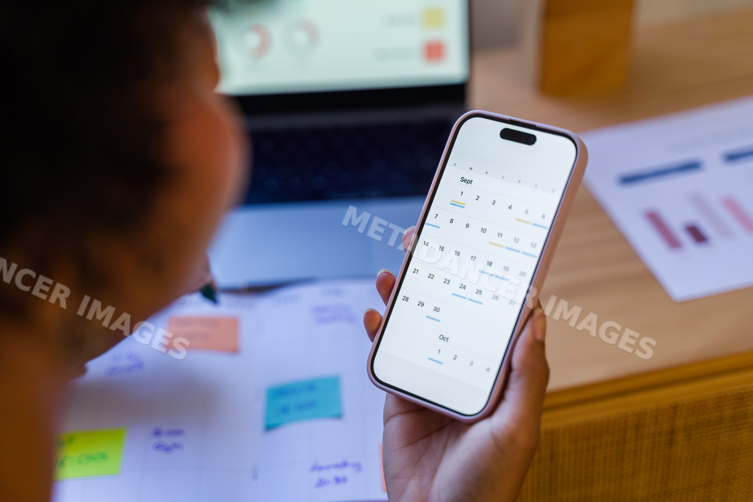 African American person viewing calendar app on smartphone