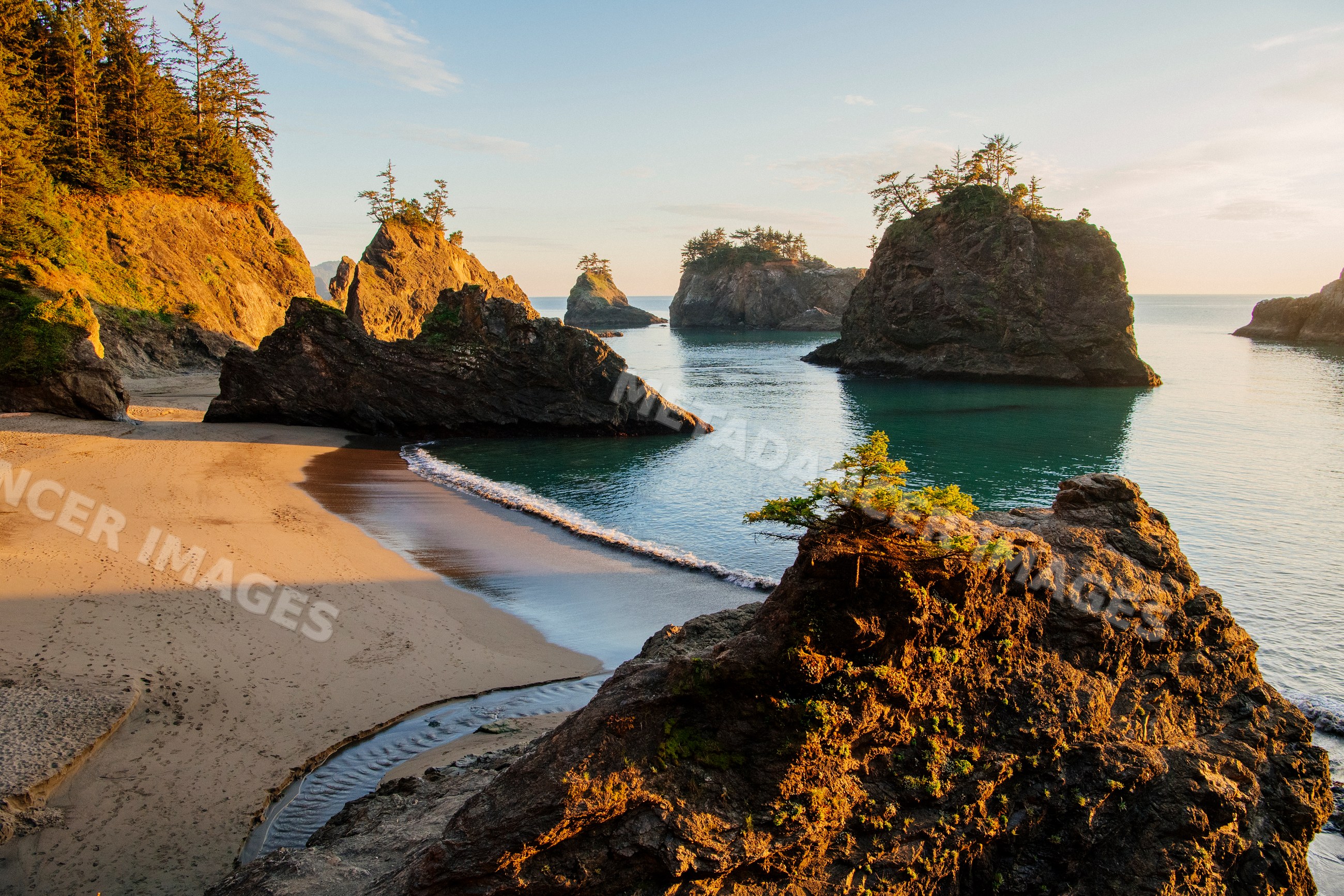 Sunlit rock formations and beach, Oregon