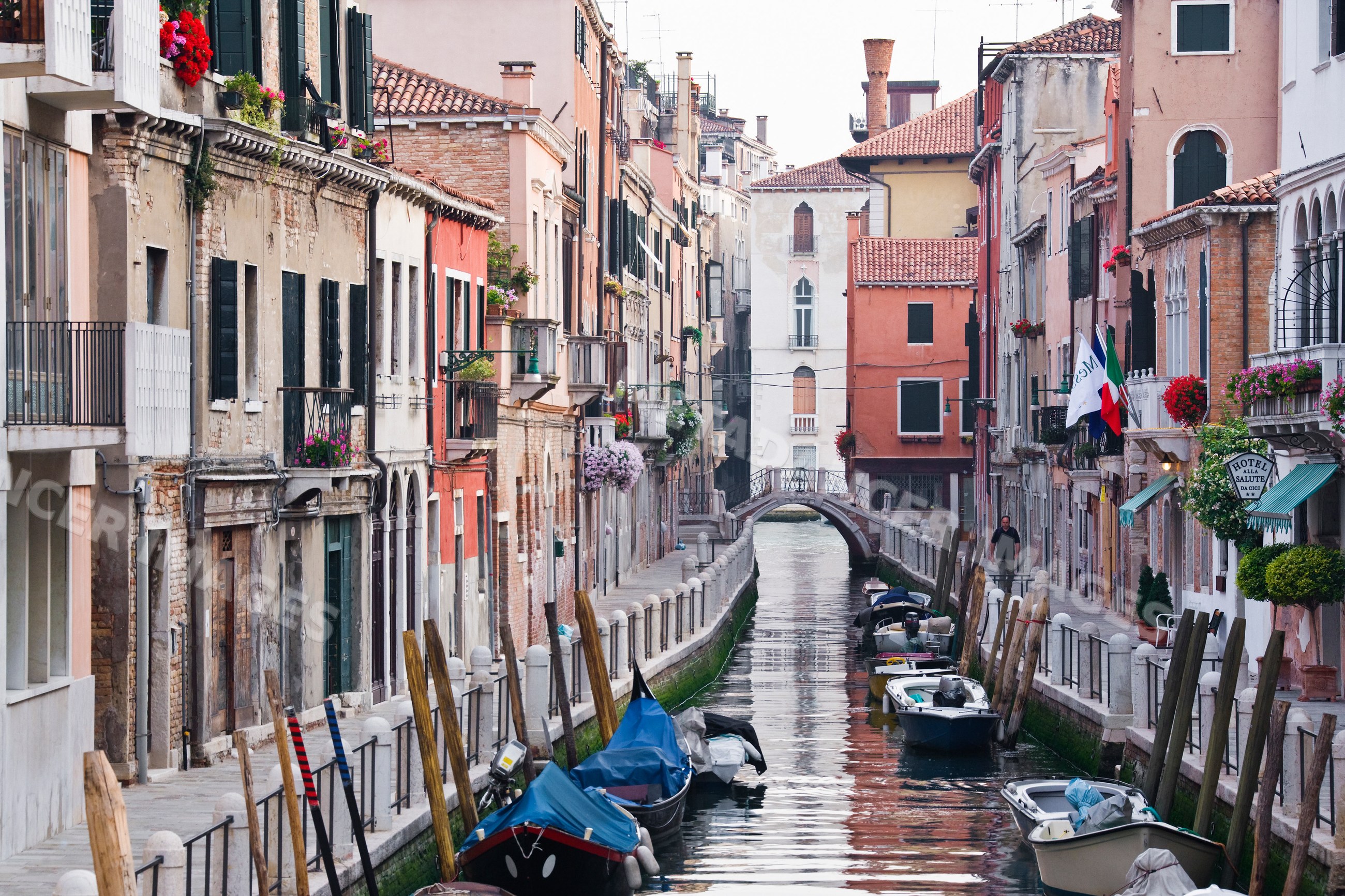 Venice canal with boats and historic buildings along narrow waterway