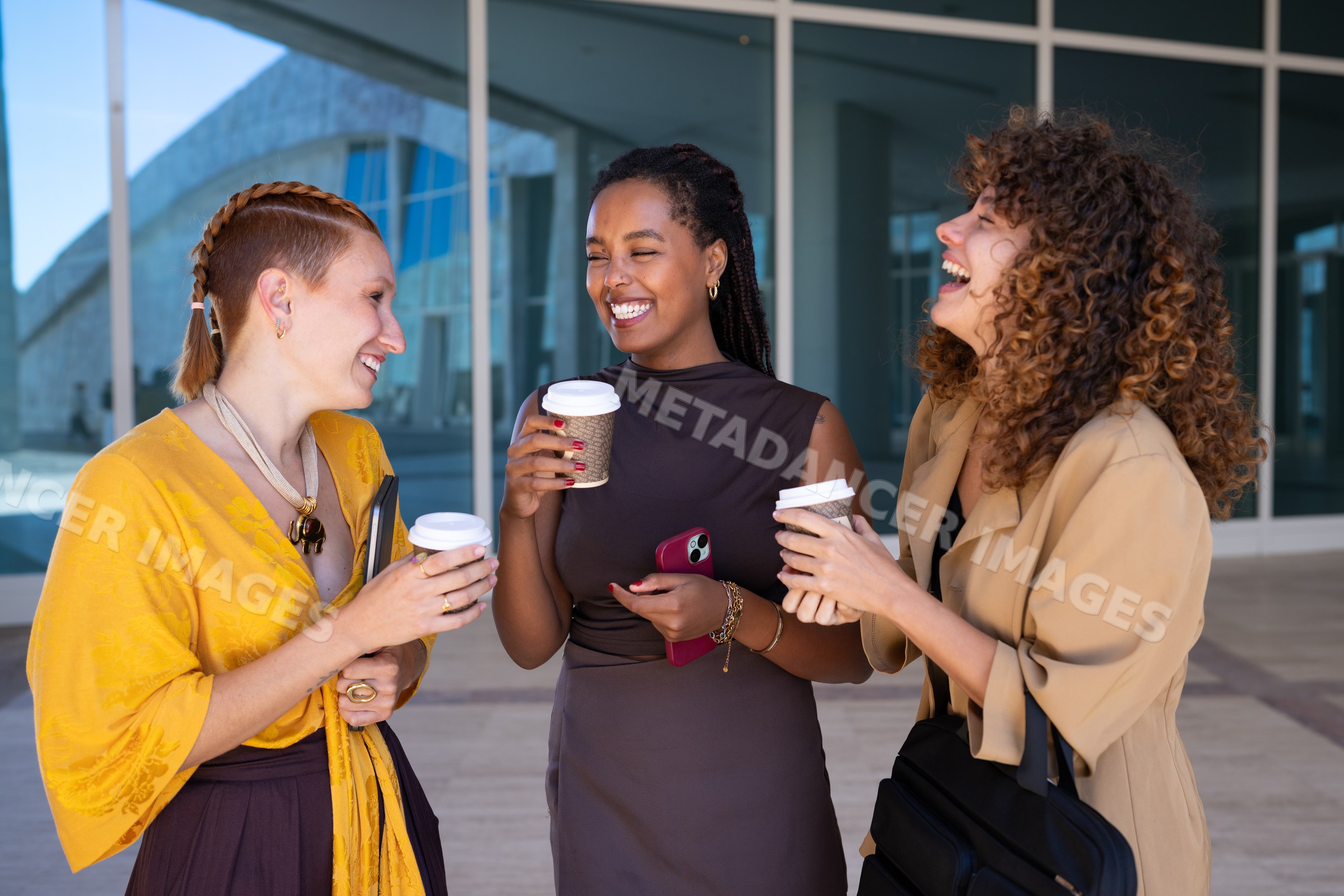 Group of African American and white women laughing and holding coffee