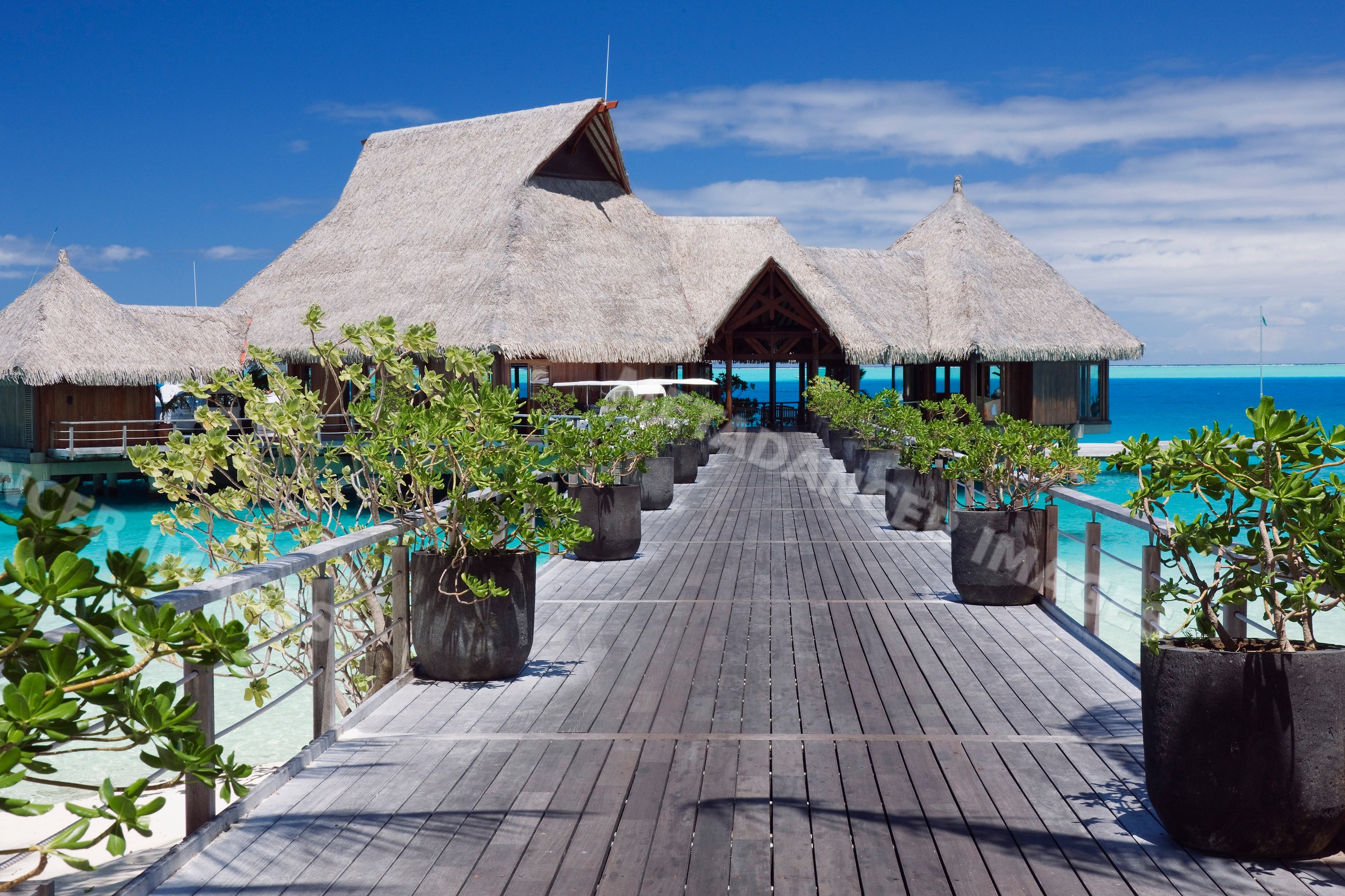 Overwater bungalows and wooden pier over turquoise water
