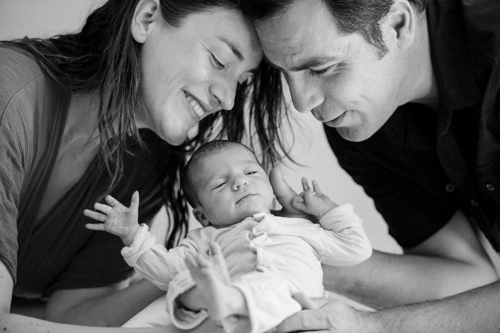 Newborn baby with parents sharing a tender moment