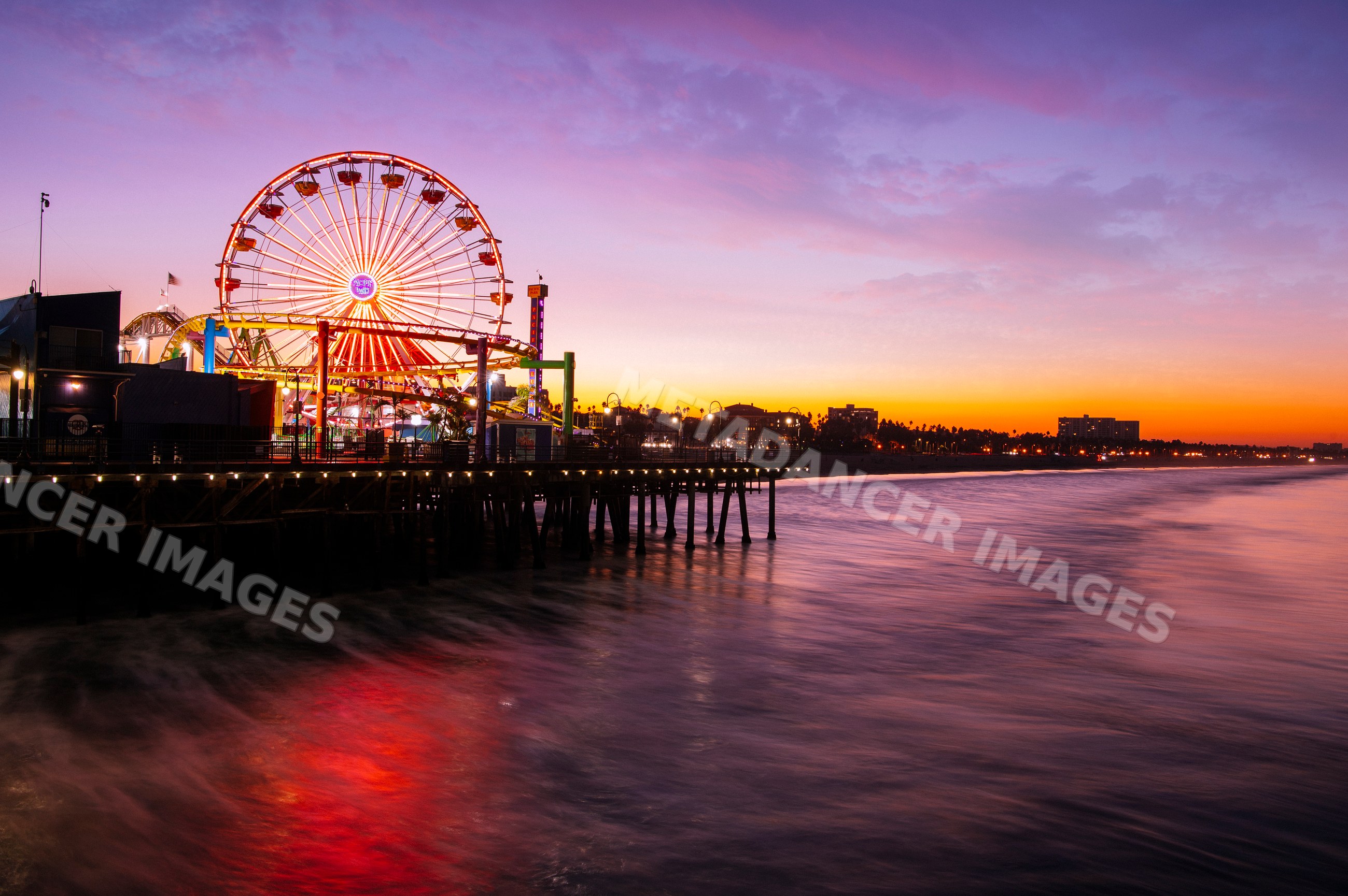Sunset with illuminated ferris wheel at Santa Monica pier