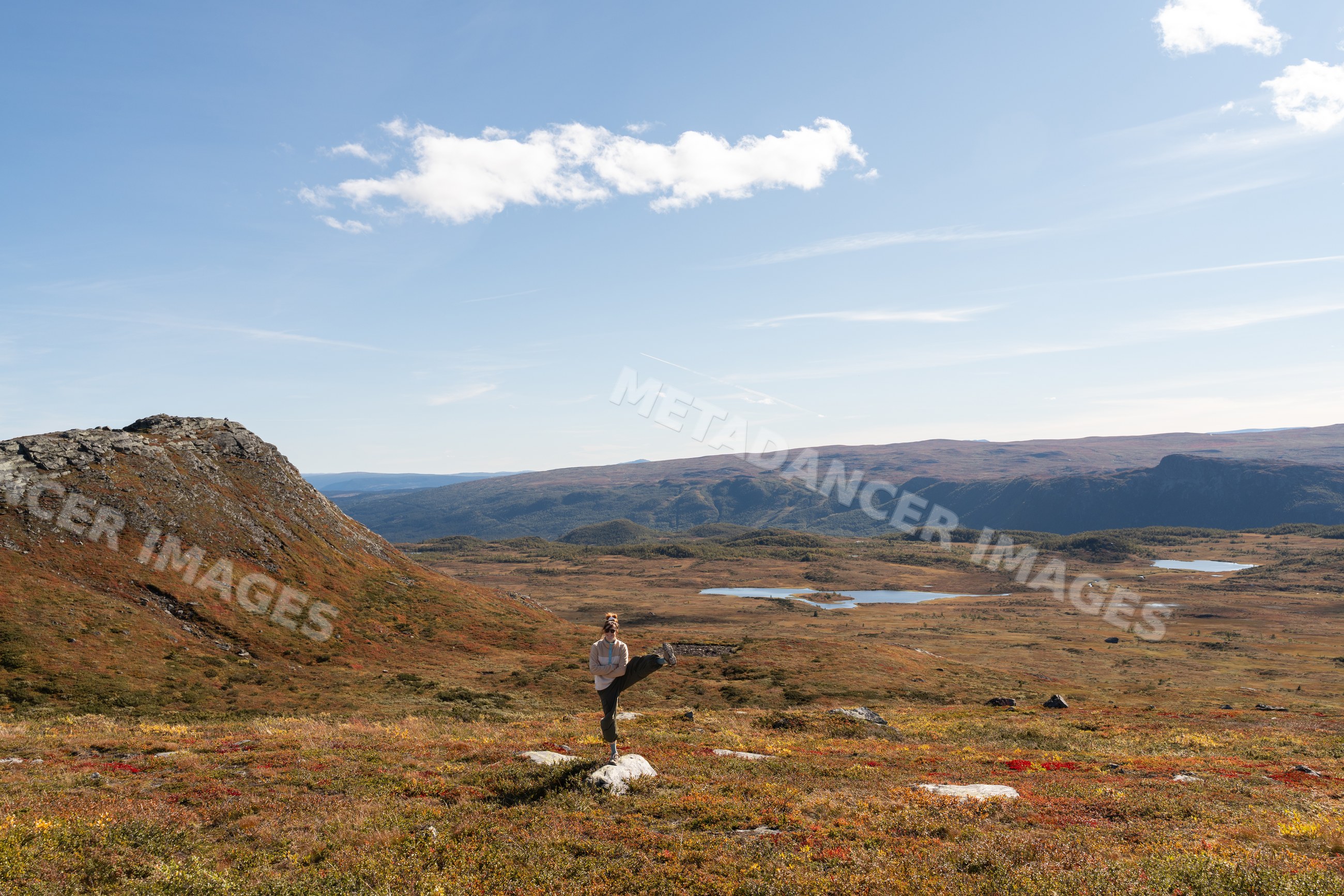 Person stretching in autumn mountain landscape with lakes