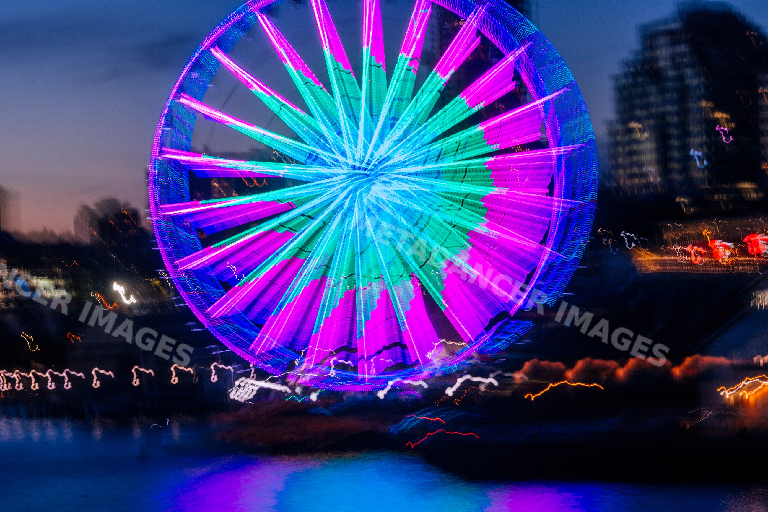 Neon-lit ferris wheel reflecting over water at night in Seattle