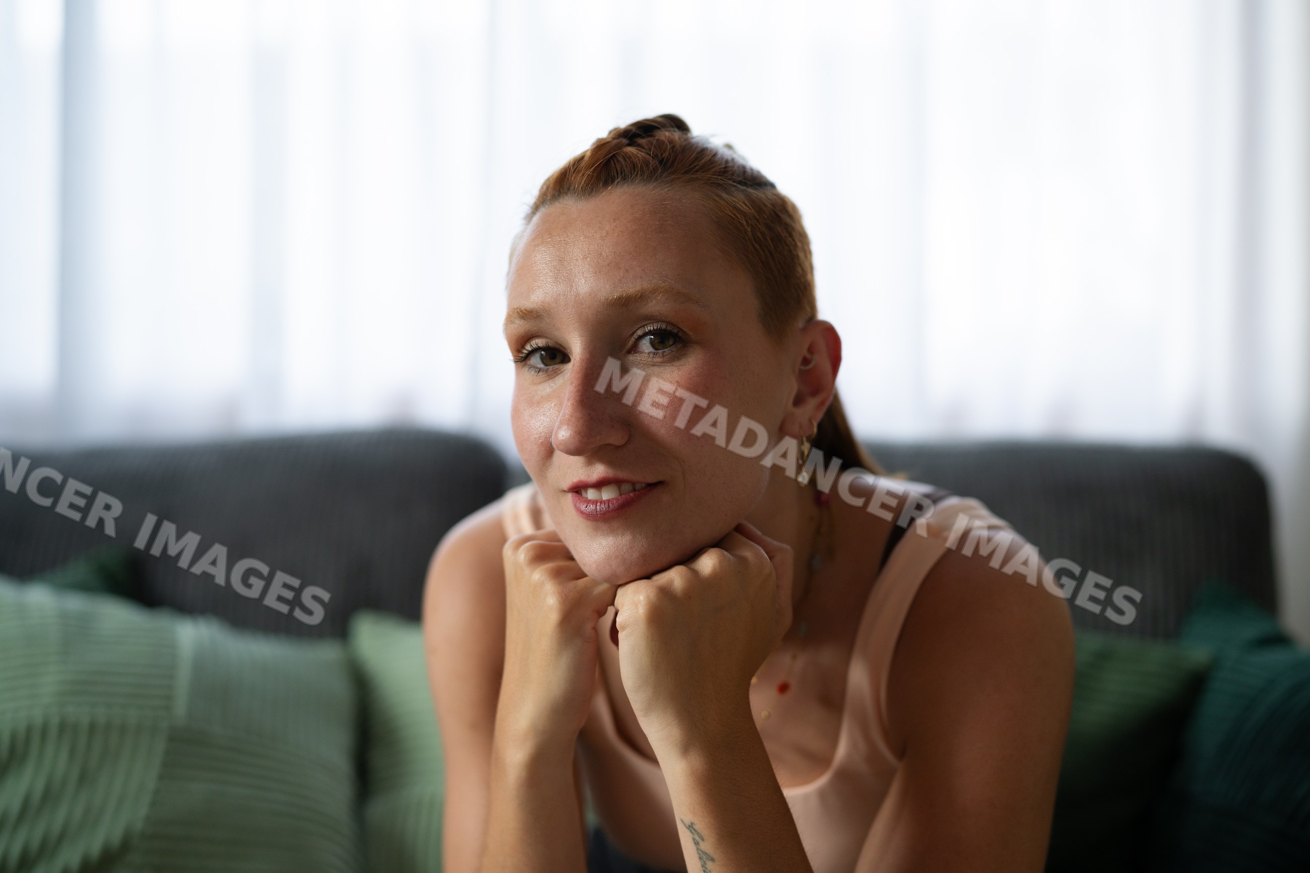 A white woman with red hair resting her chin on her hands