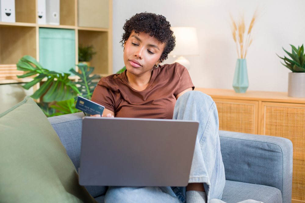 African American woman shopping online with credit card and laptop