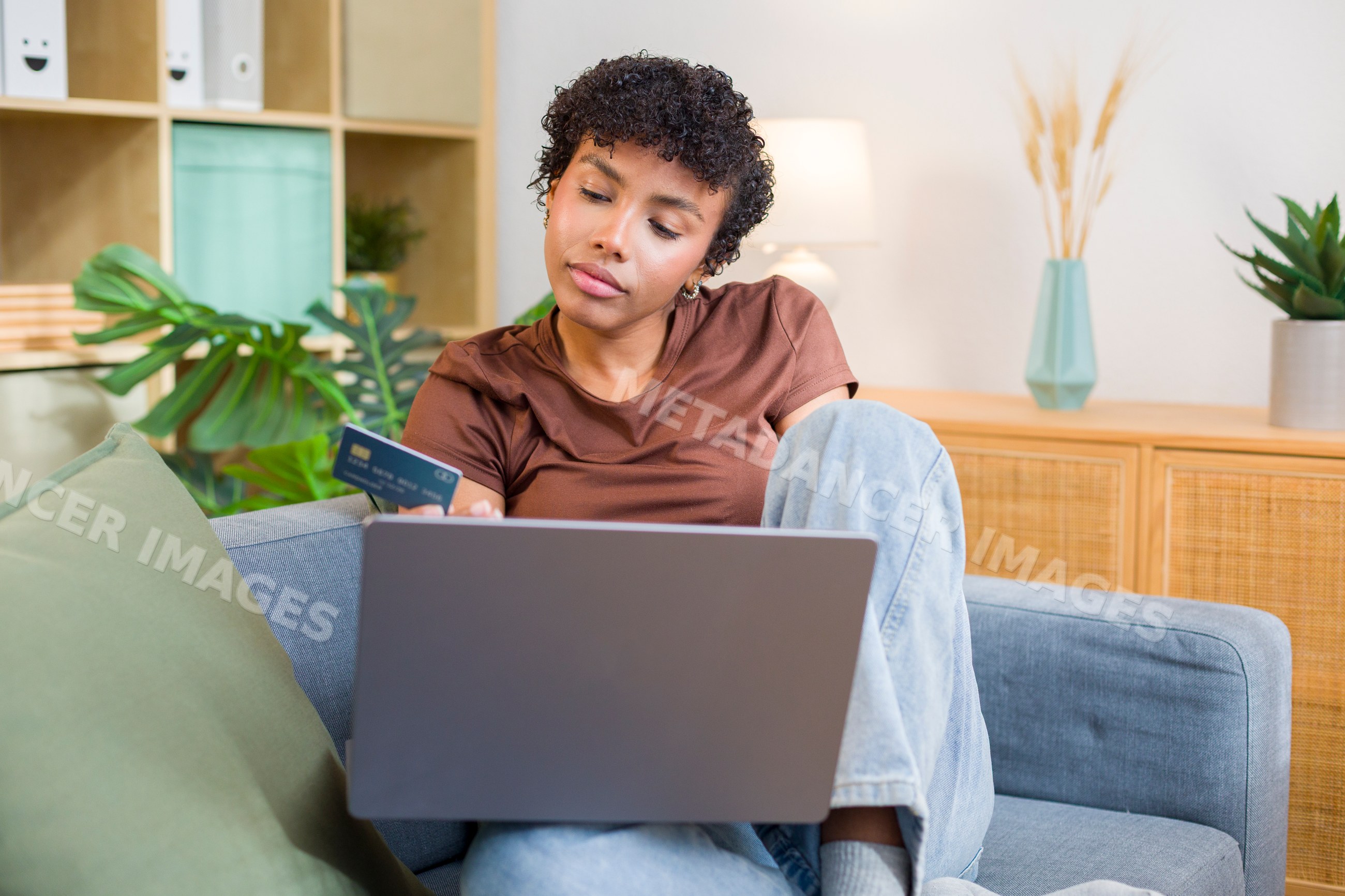 African American woman shopping online with credit card and laptop