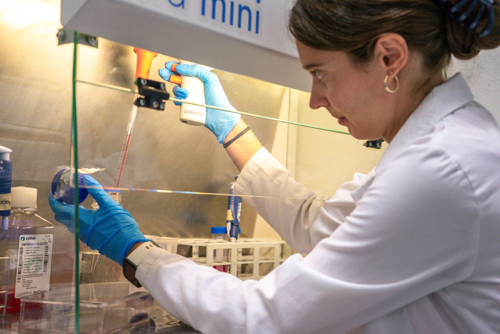 Scientist using pipette in a laboratory with test tubes and research