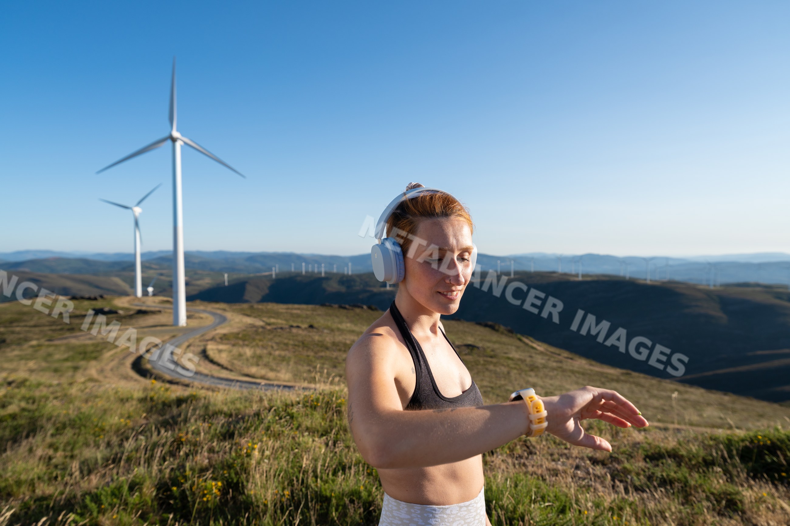 A white woman checks her fitness tracker during outdoor workout