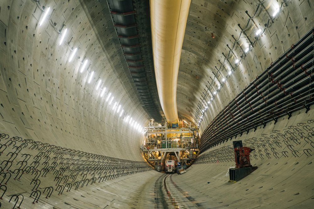 Large concrete tunnel with drilling equipment under construction