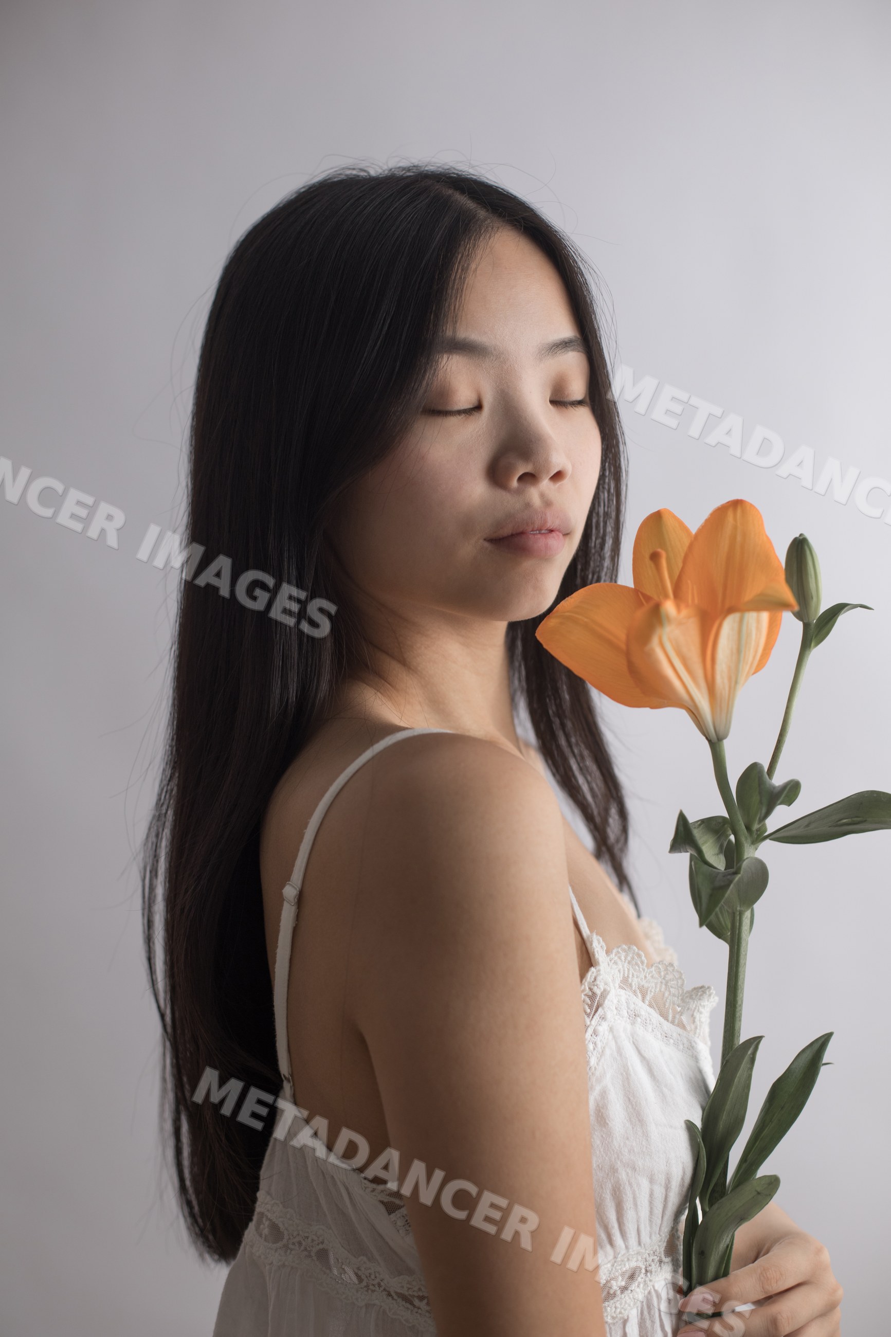 Southeast Asian woman holding orange lily and bud