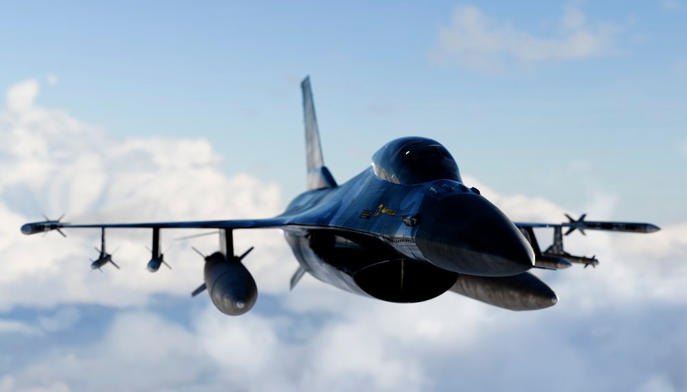 A jet fighter aircraft equipped with missiles flies above the clouds