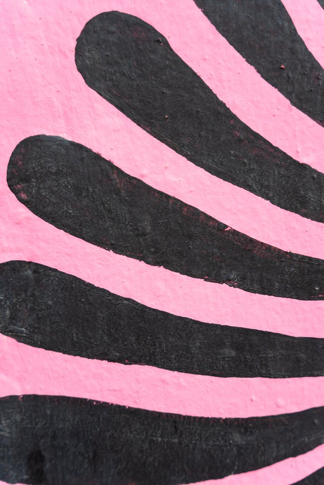 Abstract black pattern painted on pink textured wall