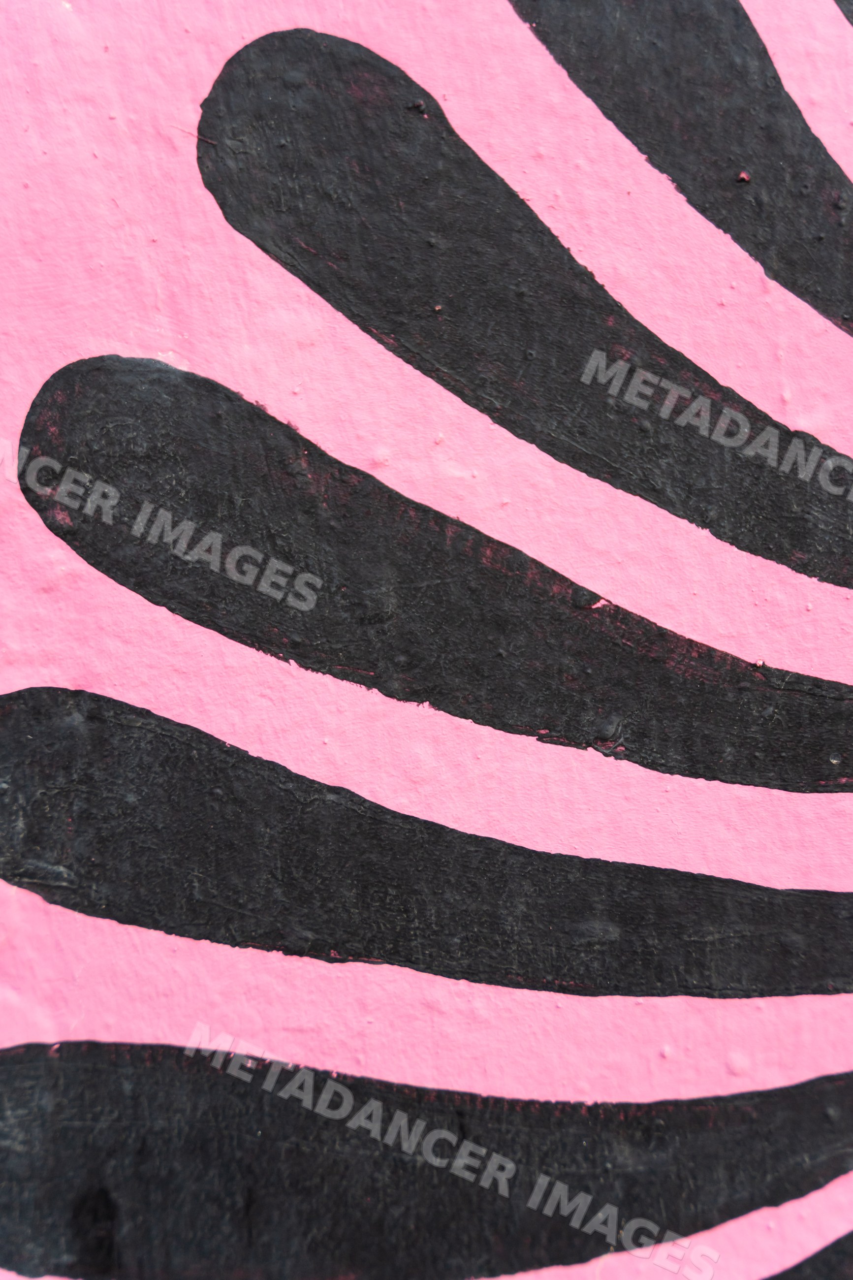 Abstract black pattern painted on pink textured wall