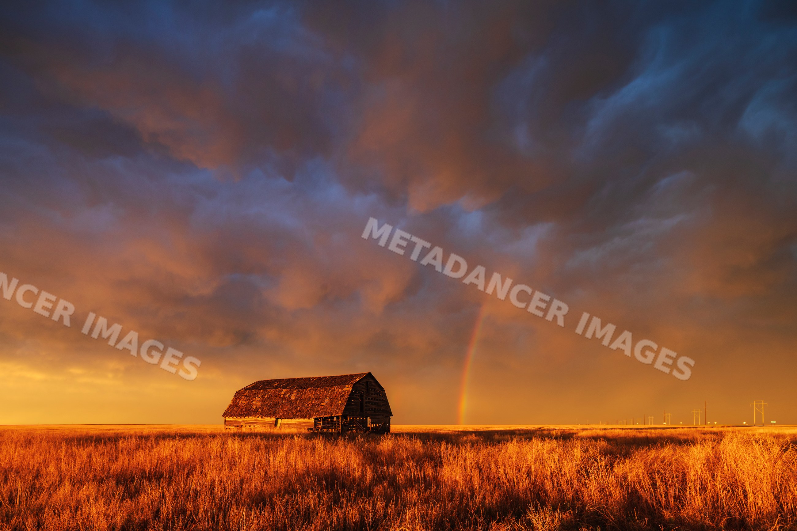 Old barn with Rainbow at Sunset in rural oklahoma grassland