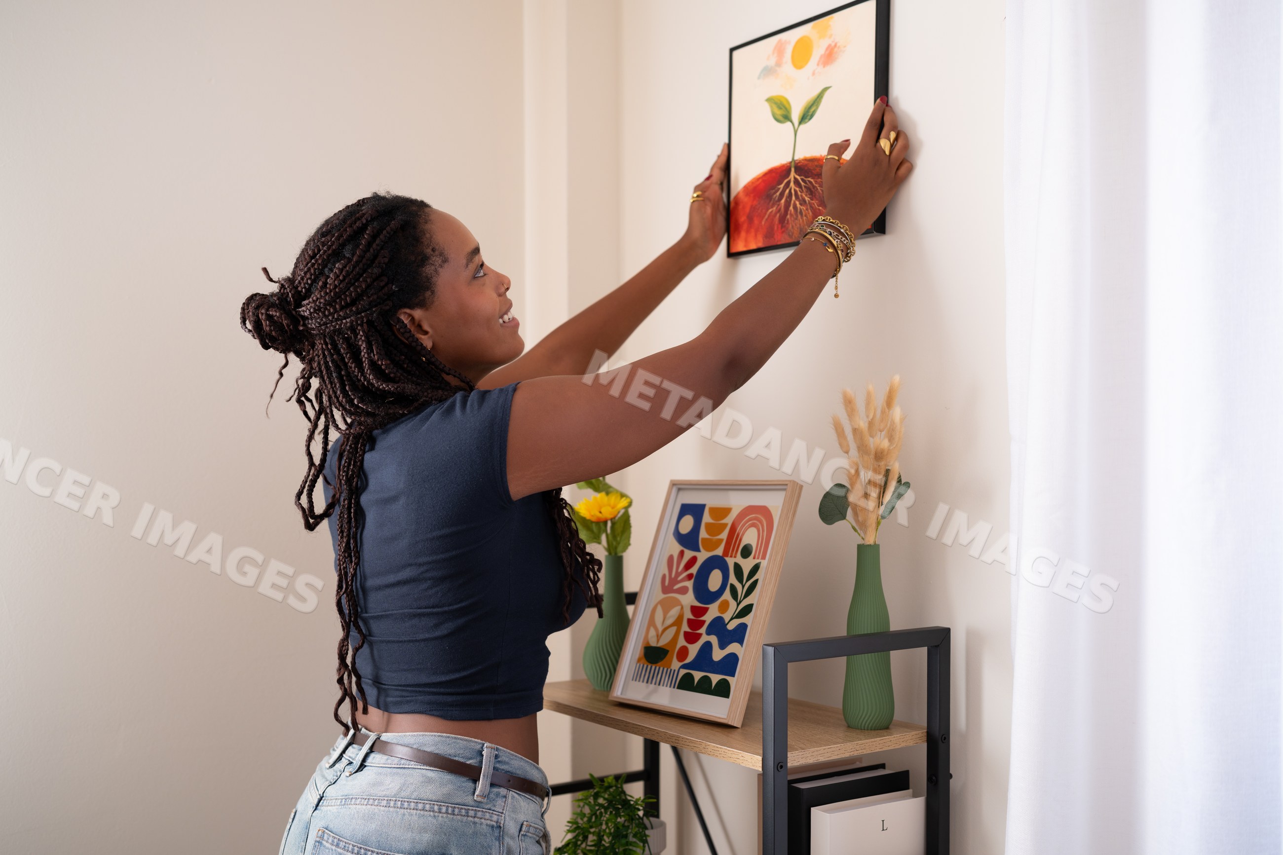 African American woman decorating a home office wall in a office