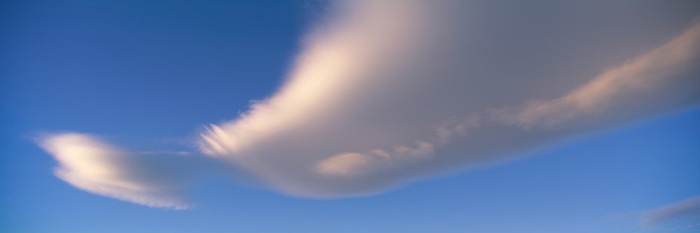 White clouds stretching across a blue sky at sunset